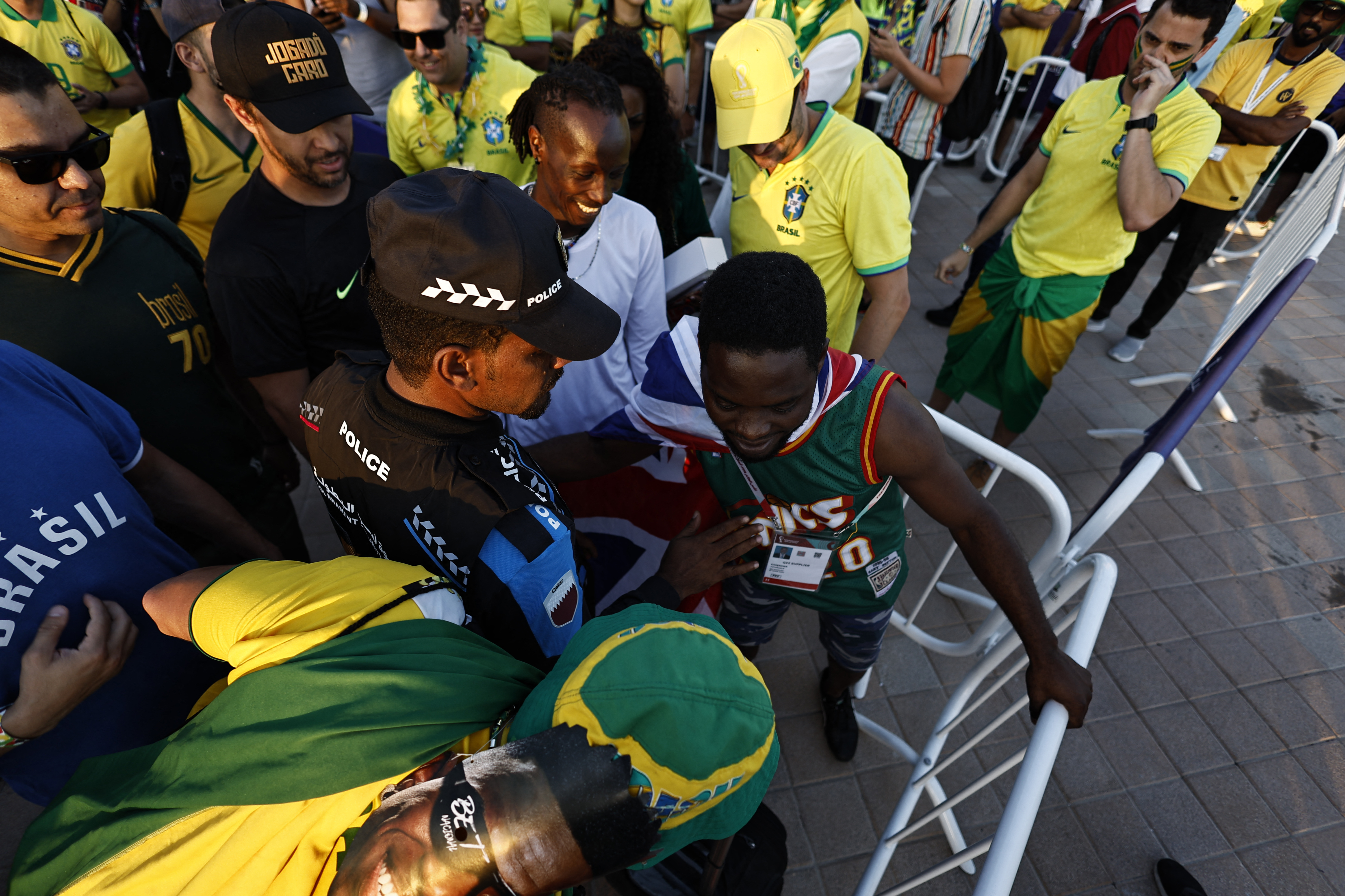 Un policía detiene a un fanático que saltó la línea de la estación del metro de Al Qassar para llegar a tiempo al estadio para el Brasil vs Suiza |  REUTERS/Hamad I Mohammed