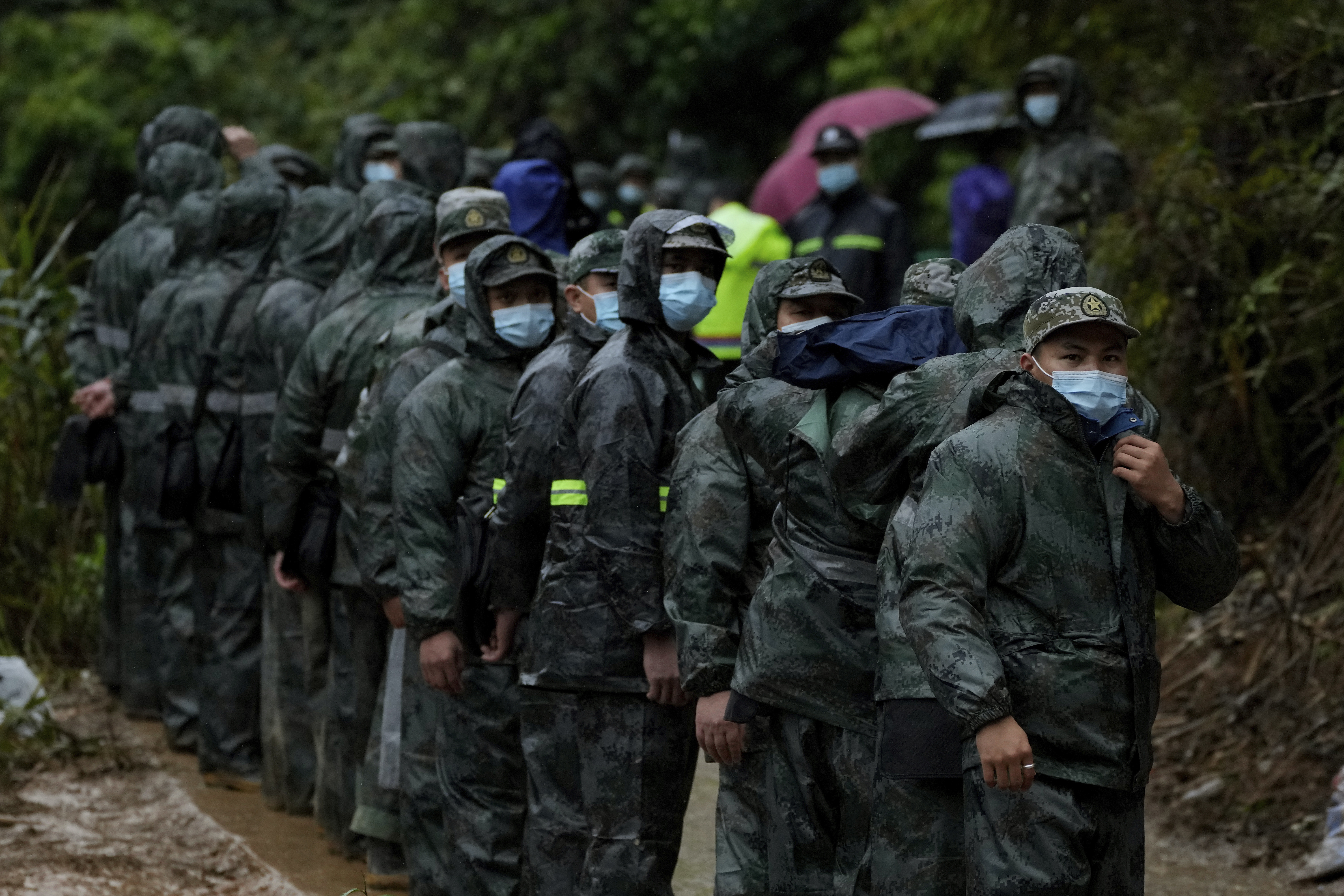 Los soldados se paran en formación mientras se preparan para dirigirse al lugar donde se estrelló el vuelo 5735 de China Eastern para buscar la caja negra. (Foto AP/Ng Han Guan)