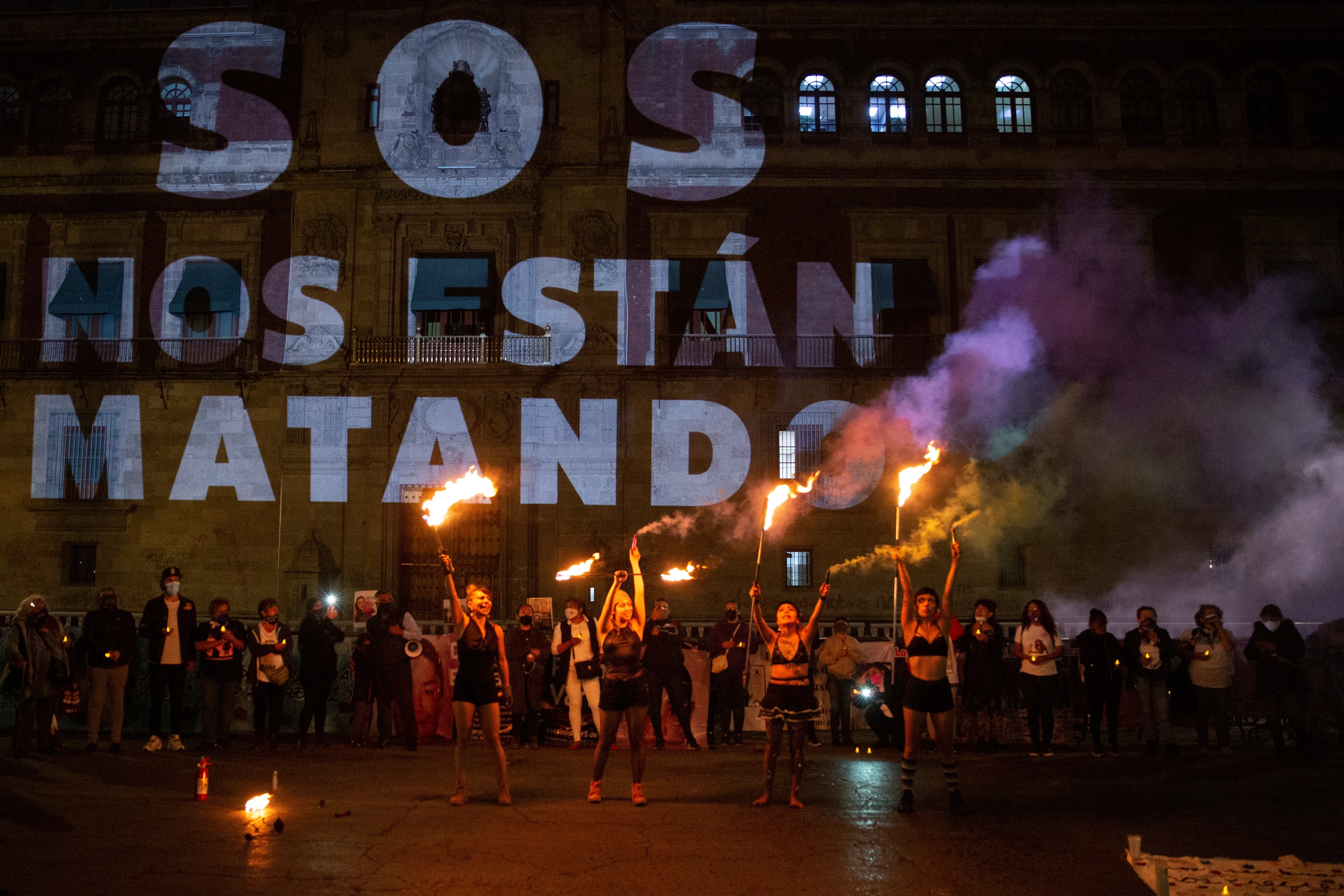 Un grupo de colectivo feministas encienden antorchas en protesta por feminicidios en Palacio Nacional de la Ciudad de México. EFE/Carlos Ramírez
