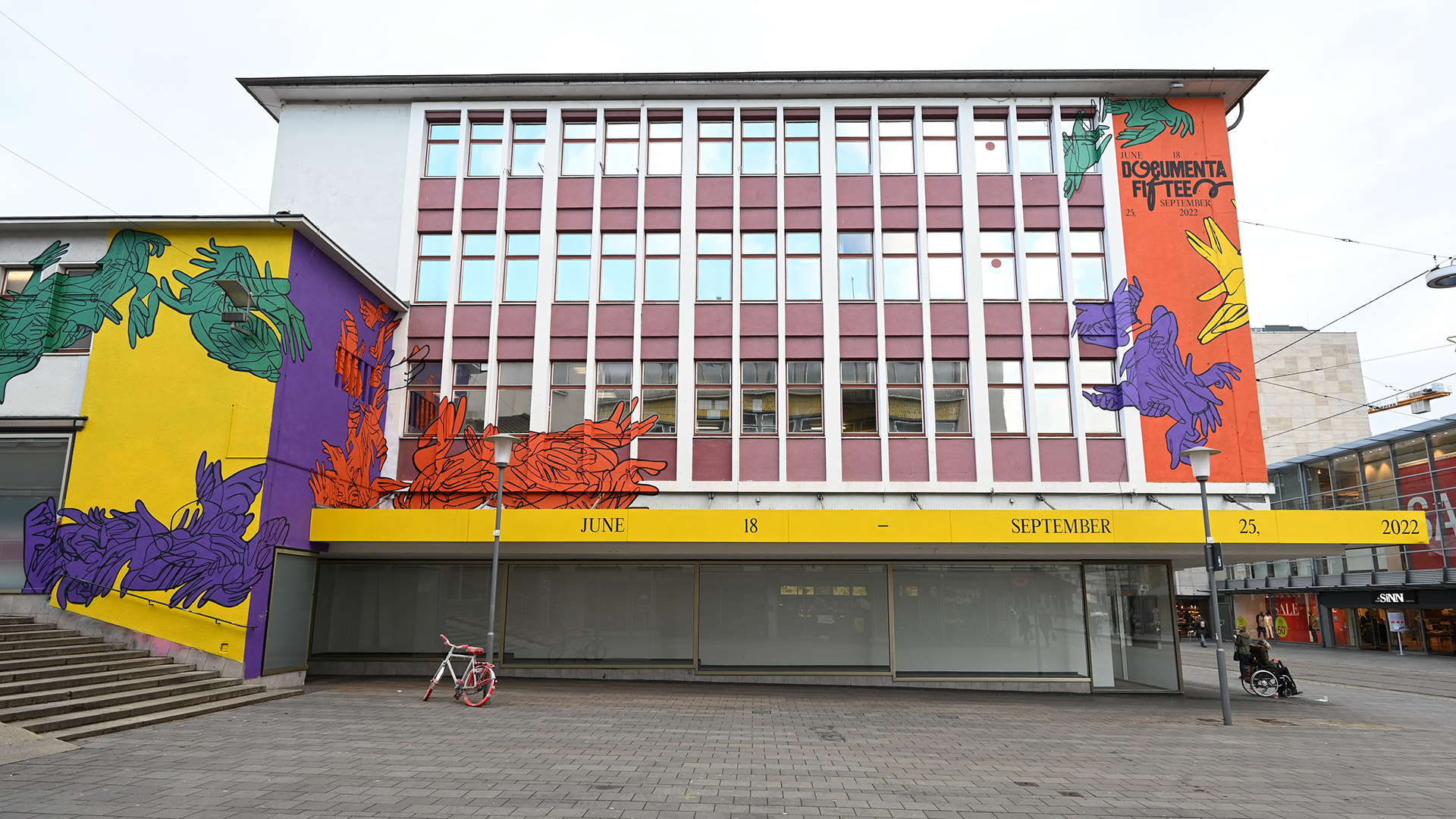 La fachada de la Ruruhaus, sede de Documenta quince, en el centro de la ciudad, está decorada con los colores y el logotipo de Documenta