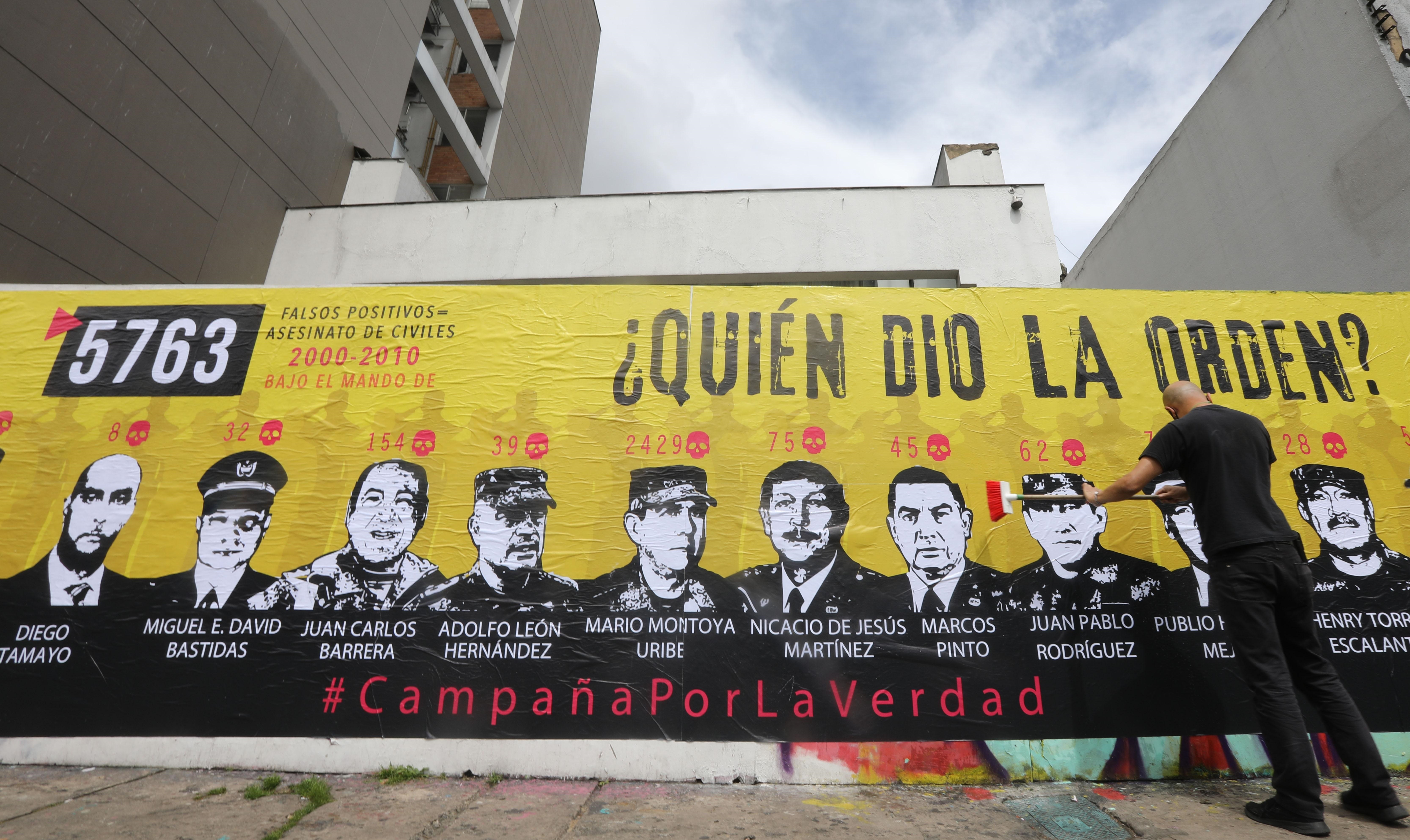 Un hombre participa hoy en la elaboración de un mural sobre los falsos positivos, en Bogotá. (Colombia). EFE/ Carlos Ortega
