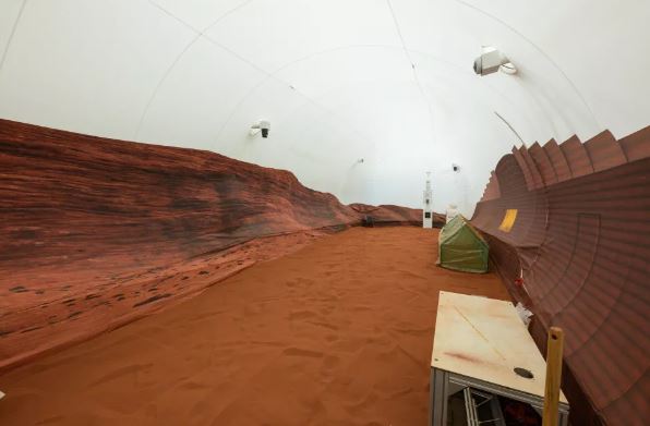 La parte trasera de la casa tiene un patio con arena roja y paredes que simulan el paisaje marciano