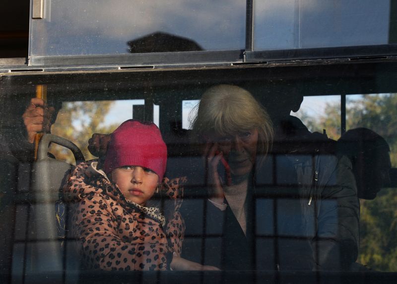 Evacuated civilians from the Russian-controlled Kherson region of Ukraine sit on a bus upon arrival at a train station in the Crimean city of Zhankoy.  October 24, 2022. REUTERS/Alexey Pavlishak/File