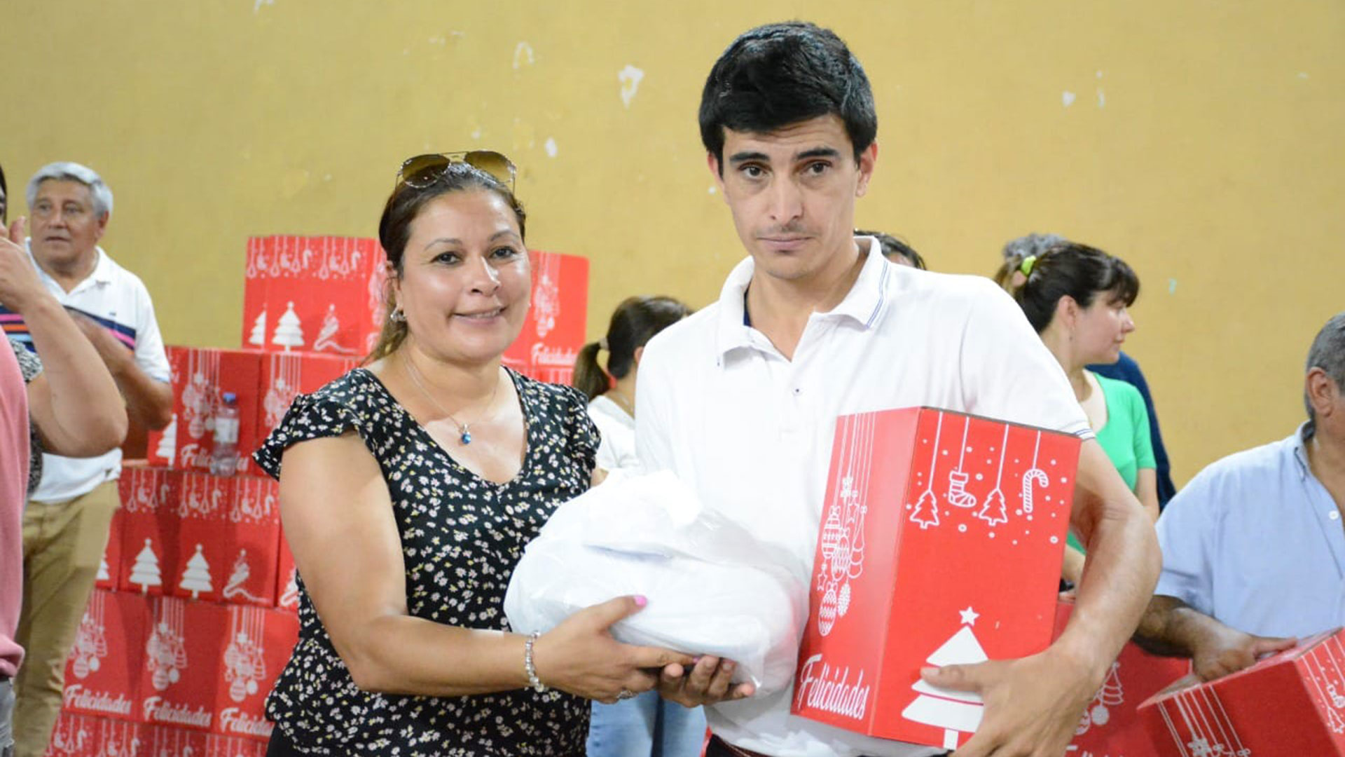 Un empleado municipal de Gobernador Virasoro, Corrientes, recibe la caja navideña y una bolsa con indumentaria. (Facebook/MuniVirasoro)