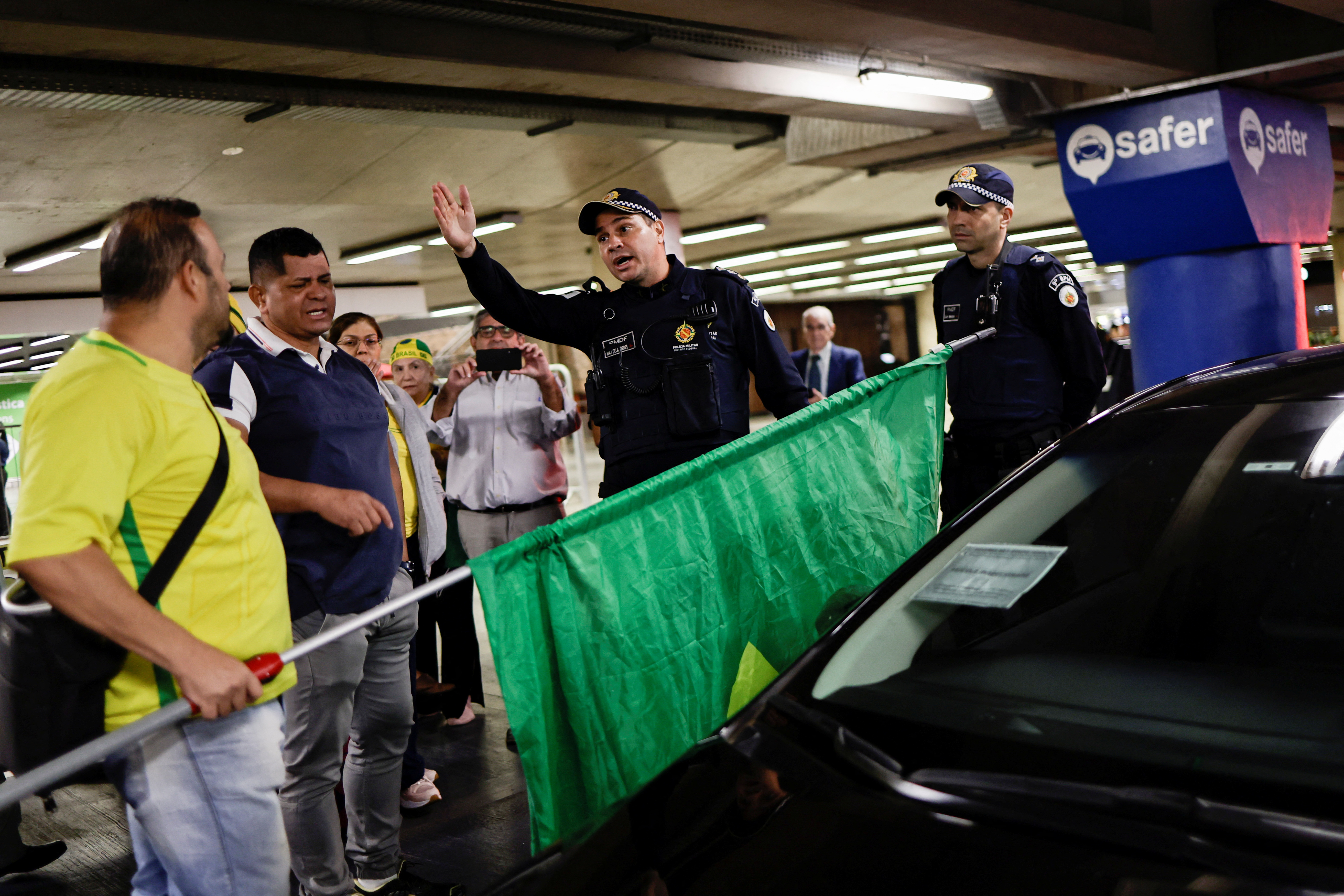 Oficiales de la policía hablan con seguidores de Bolsonaro en el aeropuerto de Brasilia (REUTERS/Ueslei Marcelino)