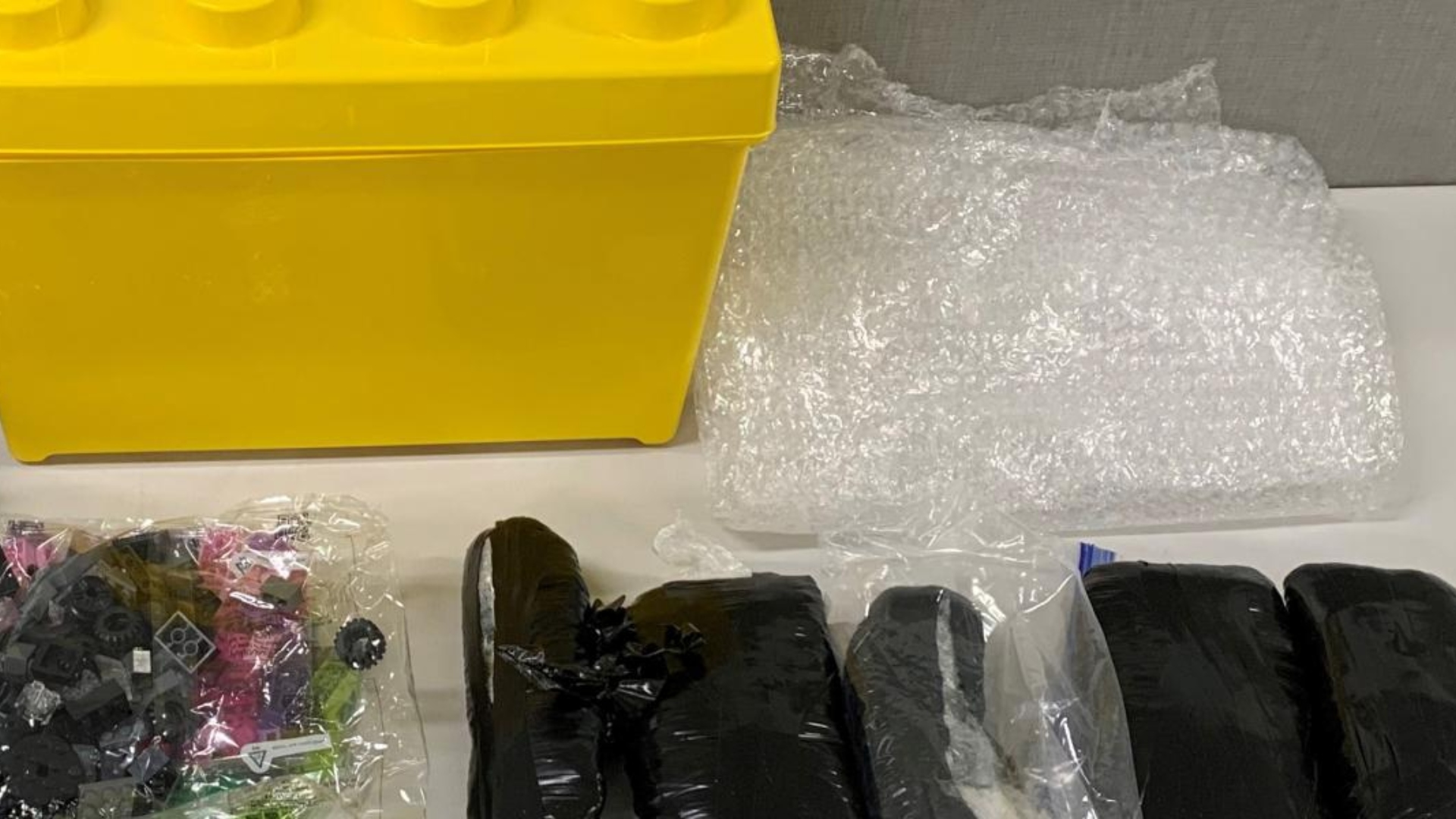 Las píldoras habían sido empaquetadas con cinta de color negro y ocultadas en los contenedores de Lego. (Foto: DEA)