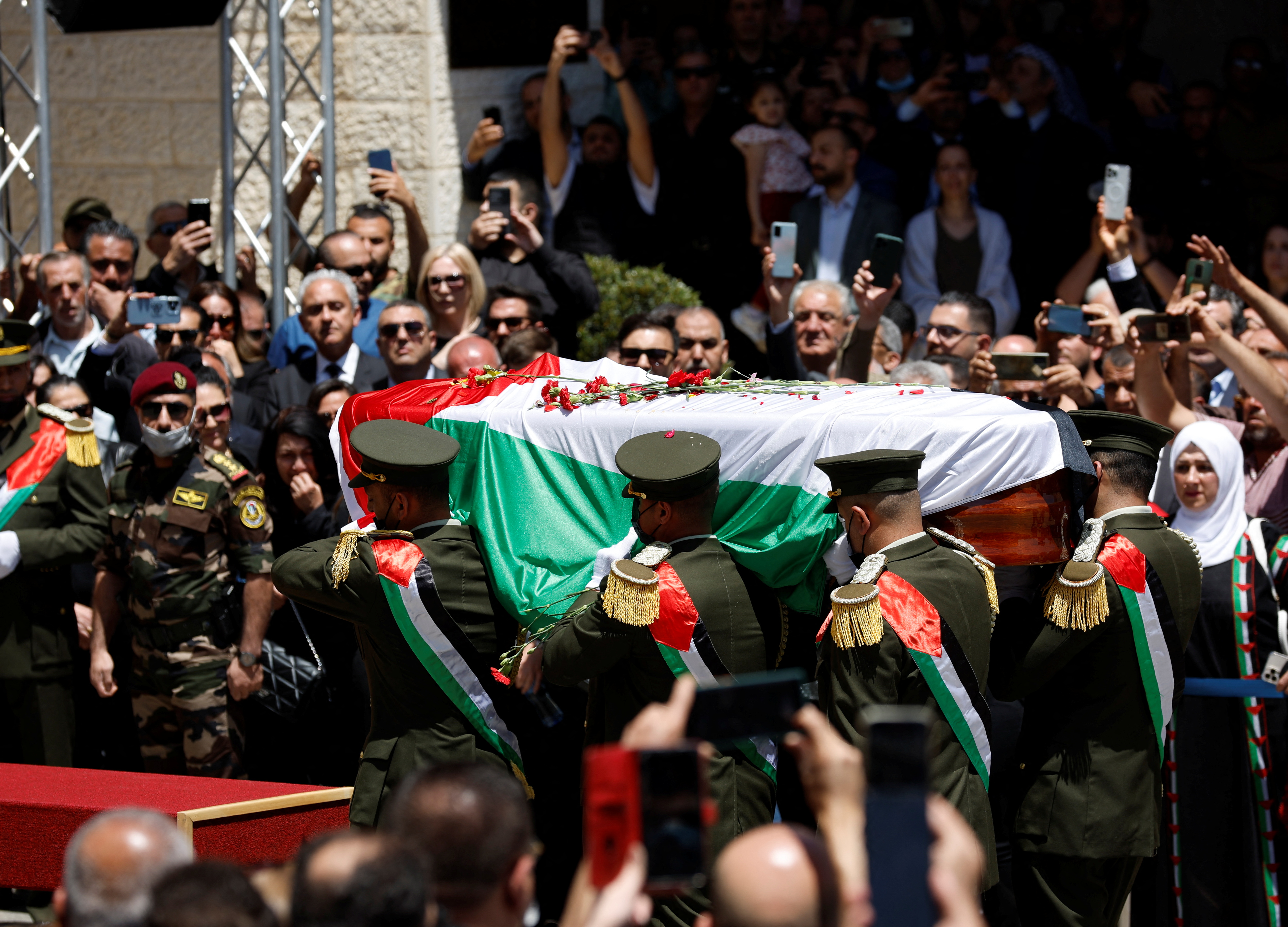 Honour guards carry the casket of Al Jazeera journalist Shireen Abu Akleh, who was killed during an Israeli raid, as Palestinians bid their farewell in Ramallah in the Israeli-occupied West Bank May 12, 2022. REUTERS/Mohamad Torokman