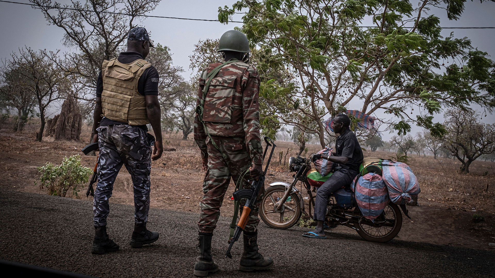Un agente de policía y un soldado de Benín detienen a un motociclista en un puesto de control a las afueras de Porga, Benín, 26 de marzo de 2022. Porga, en la región de Atakora, al norte de Benín y fronteriza con Burkina Faso, ha sufrido varios atentados yihadistas. La violencia vinculada a Al Qaeda y al grupo Estado Islámico, que ha asolado gran parte de la región del Sahel en África Occidental durante más de siete años, se está extendiendo a los estados costeros y Benín se ha convertido en el más afectado. Según el Armed Conflict Location & Event Data Project, los atentados se han multiplicado por más de diez. AP/ Marco Simoncelli/Archivo