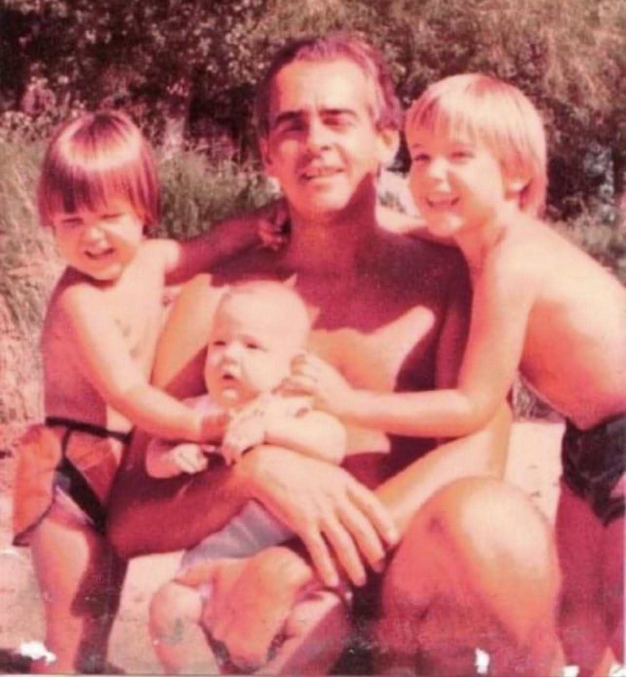 Darío Barassi bebé, en brazos de su padre y rodeado de sus hermanos, Fernando y Leandro
