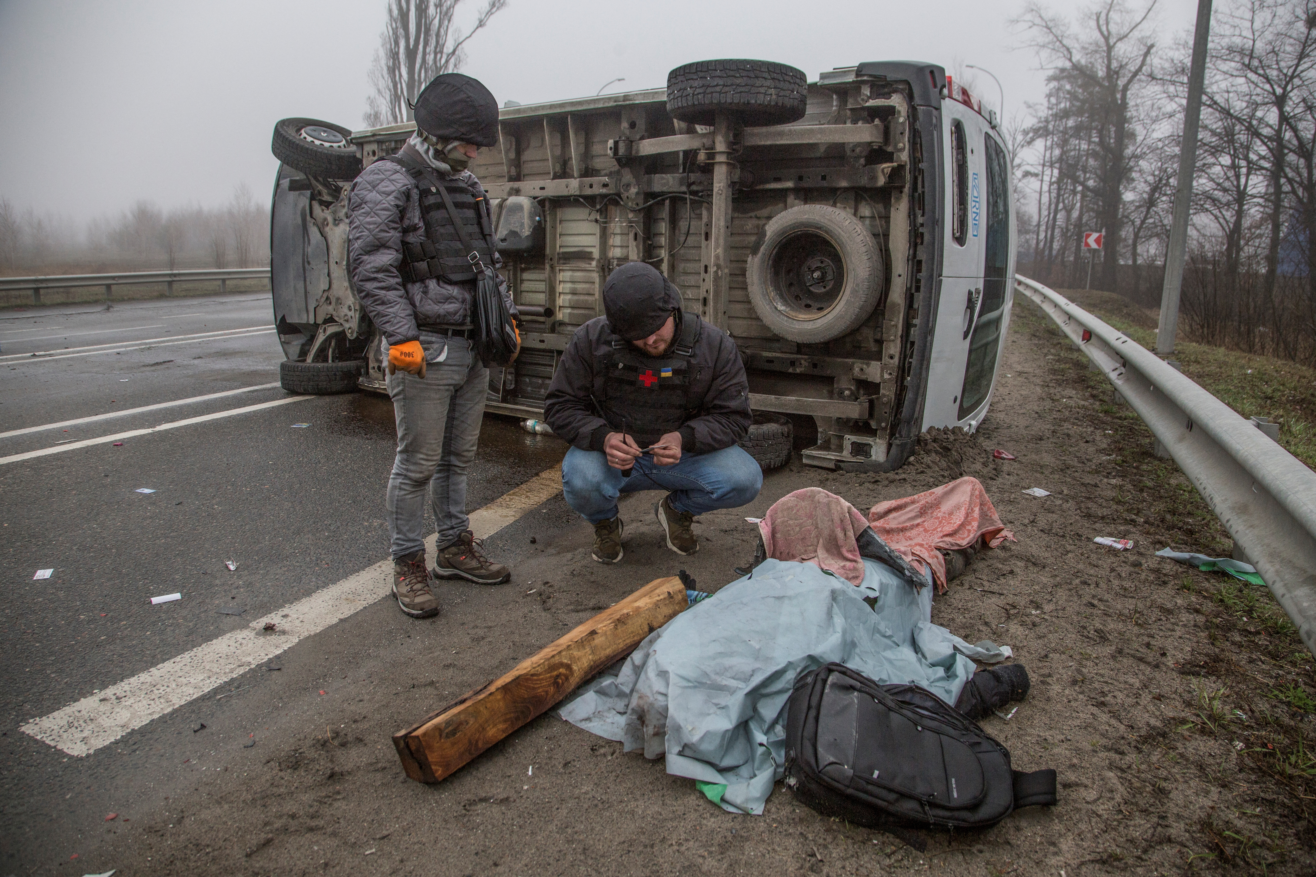 Un voluntario inspecciona el cuerpo de una persona muerta, mientras continúa el ataque de Rusia a Ucrania, en una calle de la ciudad de Bucha, en la región de Kyiv, Ucrania 1 de abril de 2022. REUTERS/Oleksandr Ratushniak