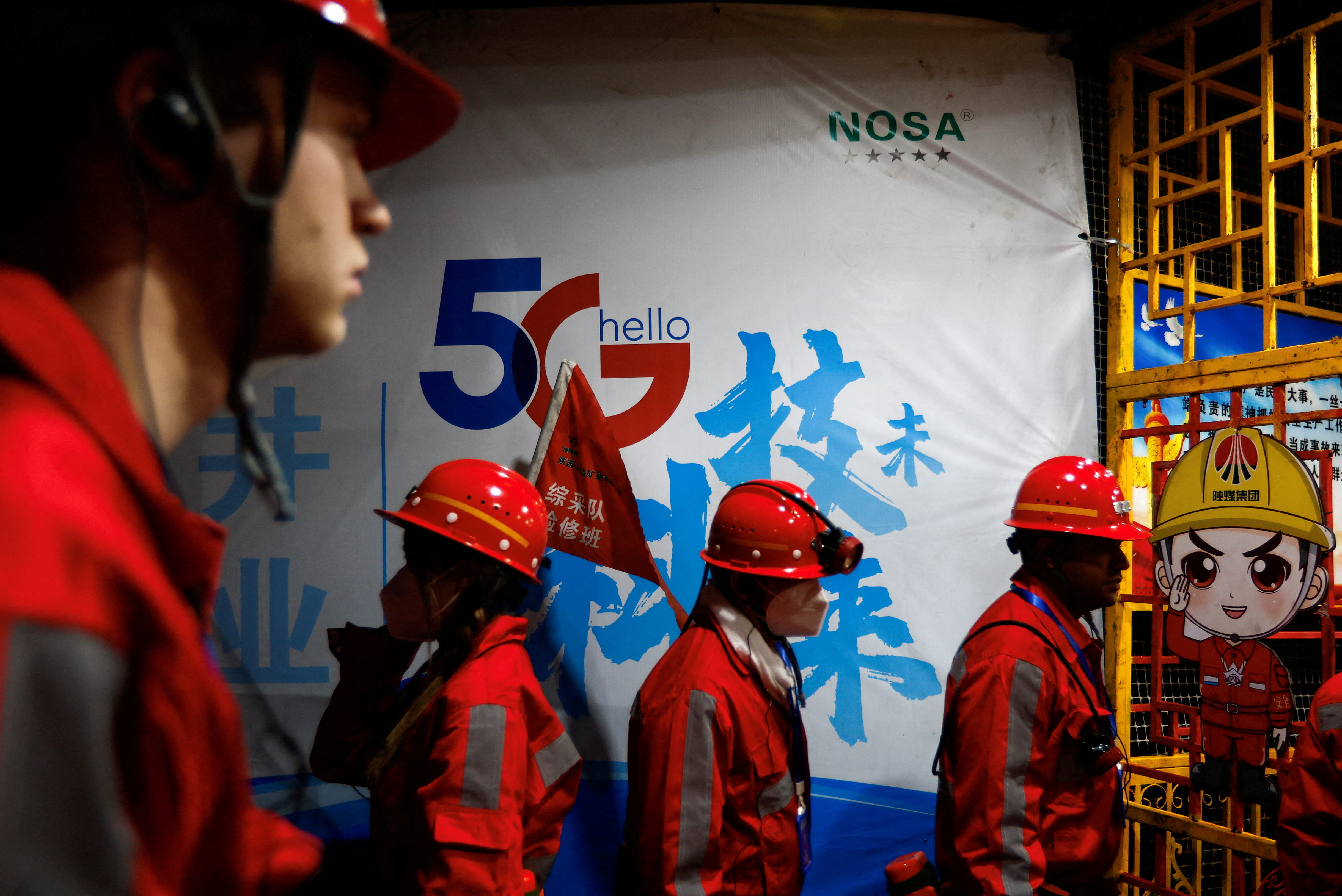 Reporters walk past a 5G sign on an underground coal surface where Huawei's 5G base stations are deployed in Shaanxi, China (Reuters/File)