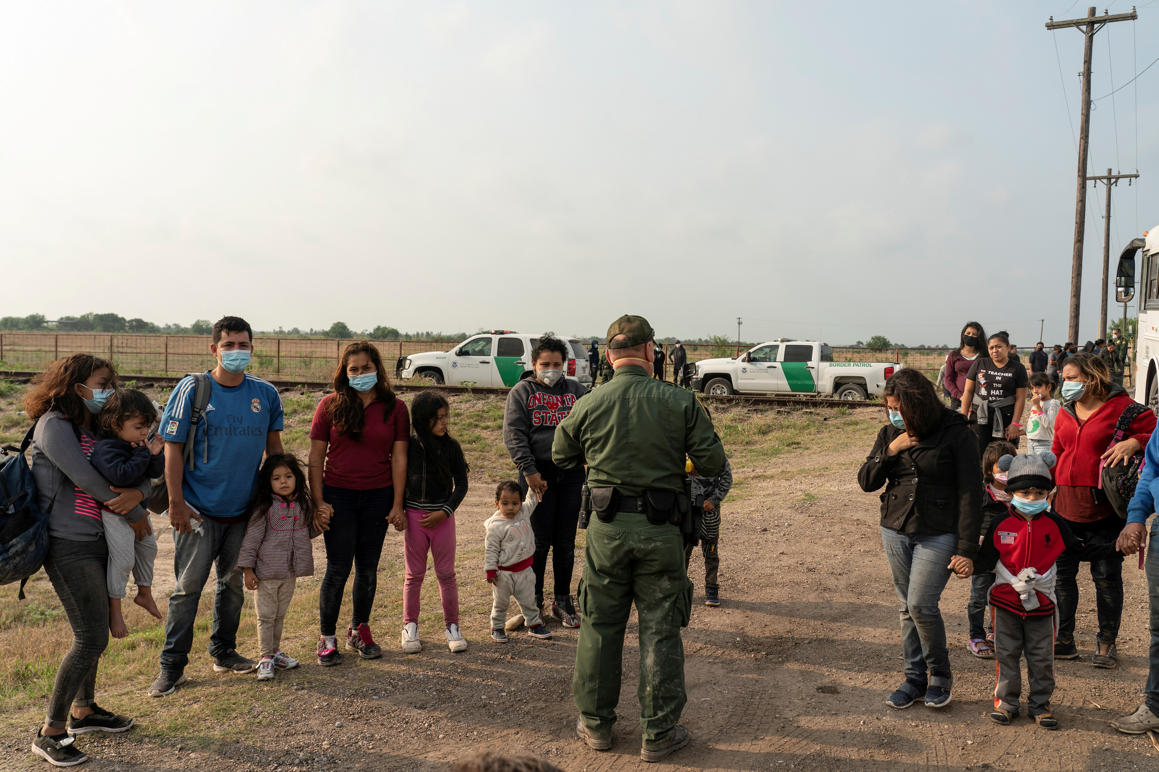 Migrantes que buscan solicitar asilo esperan a ser transportados tras cruzar el Río Grande hacia Texas (Reuters)