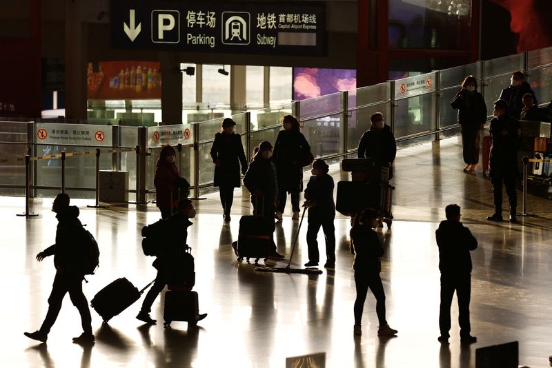 Viajeros entran en una terminal, durante el ajetreo anual de viajes de la Fiesta de la Primavera antes del Año Nuevo Lunar chino, mientras continúa el brote de la enfermedad por coronavirus (COVID-19), en el Aeropuerto Internacional de Pekín Capital, Pekín, China. 18 de enero de 2023. REUTERS/Tingshu Wang