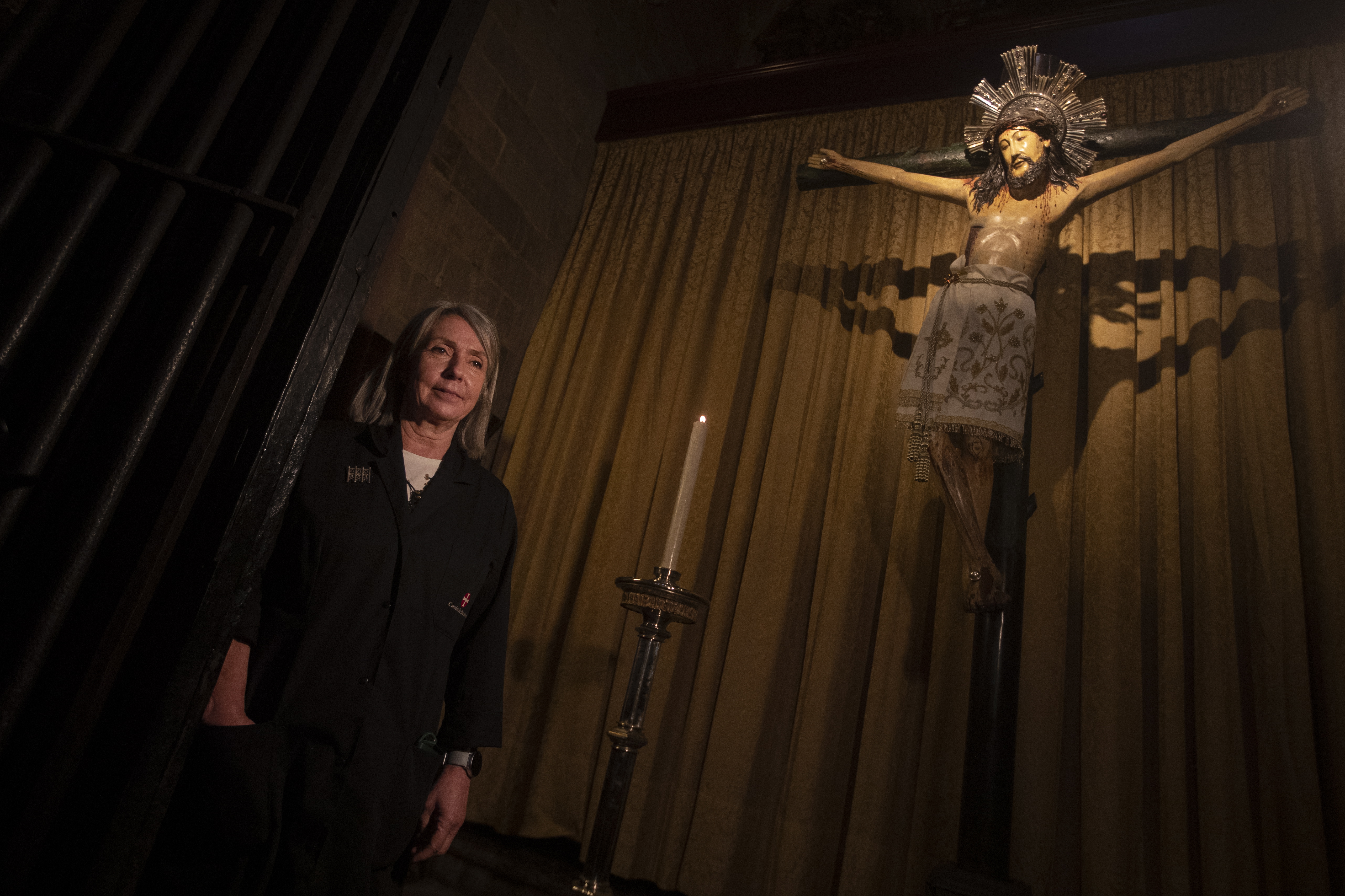 La conservadora restauradora de la Catedral de Barcelona, Ana Ordoñez, posa junto a la figura del Santo Cristo de Lepanto, el cual ha sido restaurado con una simple goma de borrar y agua caliente, descubriendose así que no es en realidad un Jesús negro, sino solo suciedad acumulada pero no desde el siglo XVI, cuando se creía que fue esculpido, sino del siglo XIII. (EFE/Marta Perez)