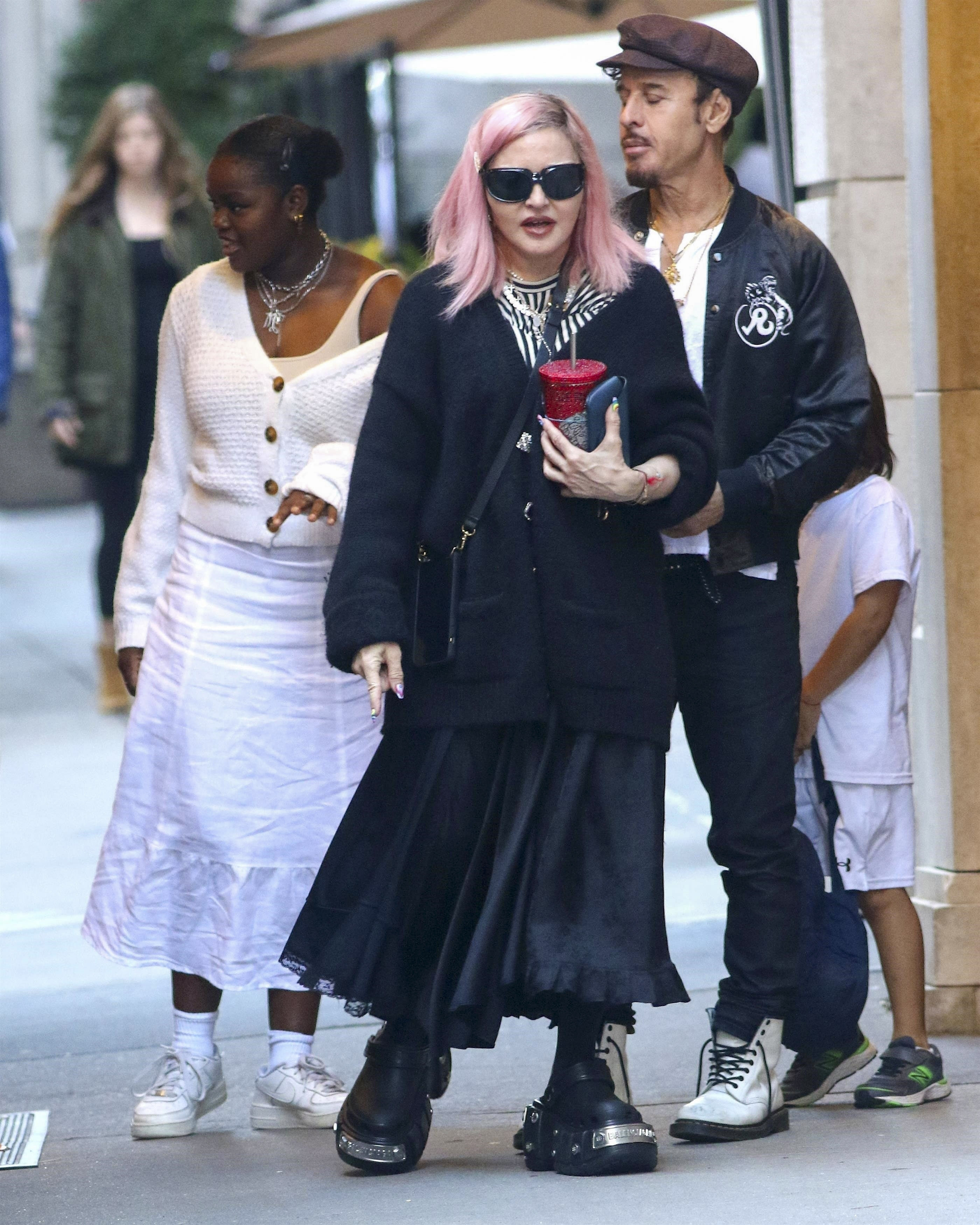 Madonna se mostró paseando en familia por Nueva York, con su pelo rosa, lució una pollera larga negra, chaqueta del mismo color oversize y crocs Balenciaga