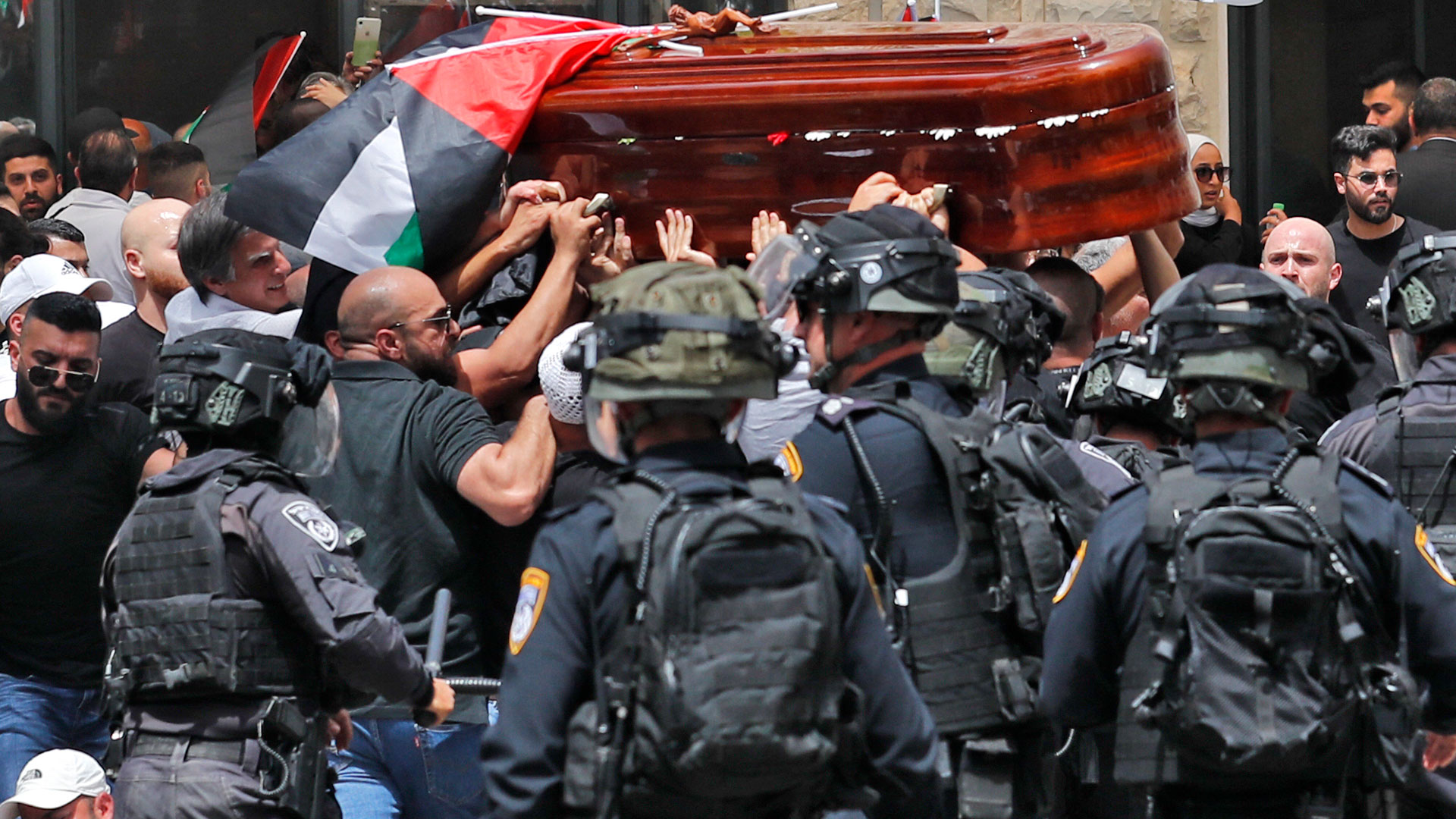 The journalist's coffin was moved through the streets amid police riots with protesters (AFP)