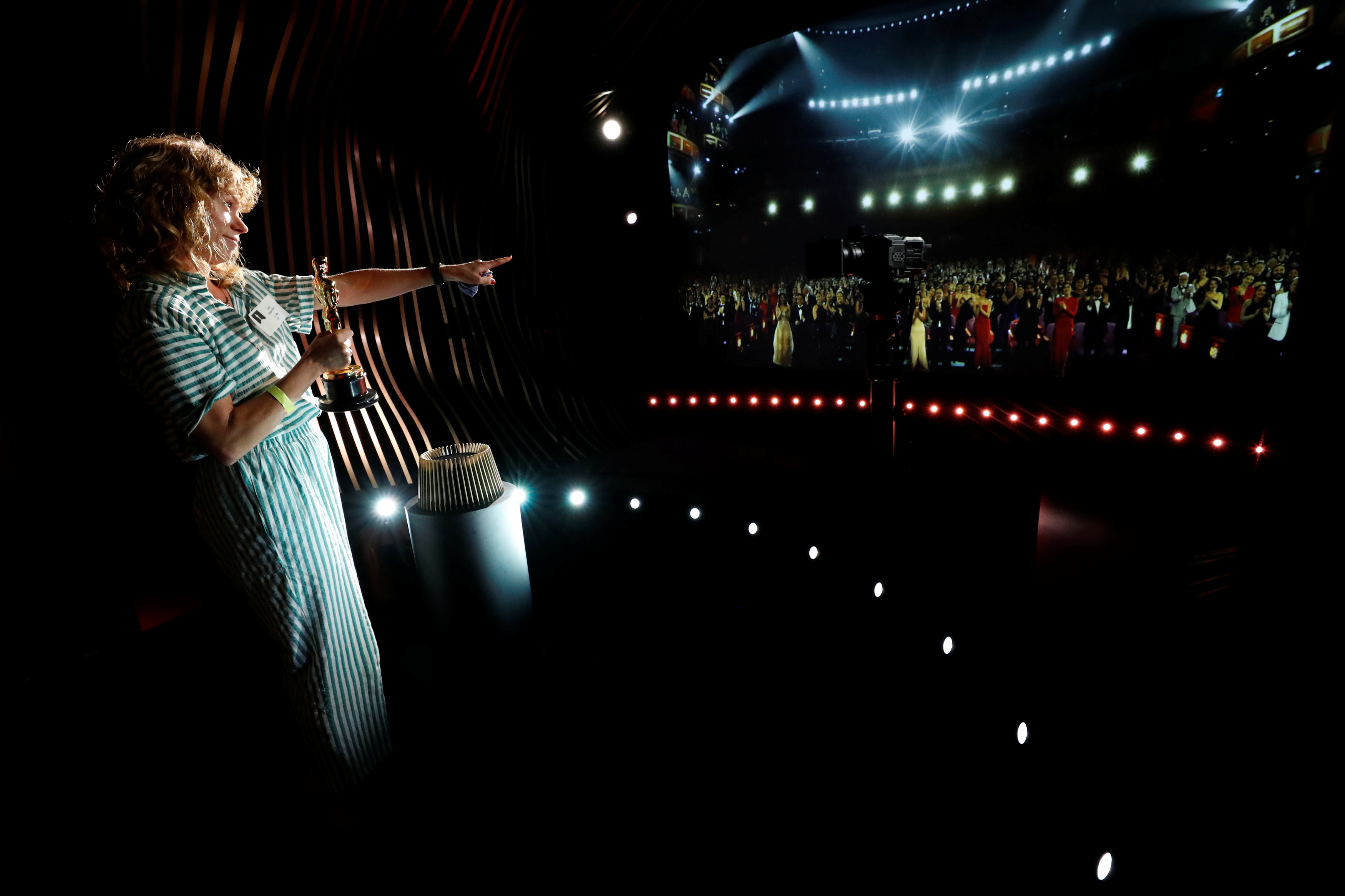 Un invitado sostiene una estatuilla real del Oscar dentro de The Oscars Experience en el Museo de la Academia (REUTERS/Mario Anzuoni)