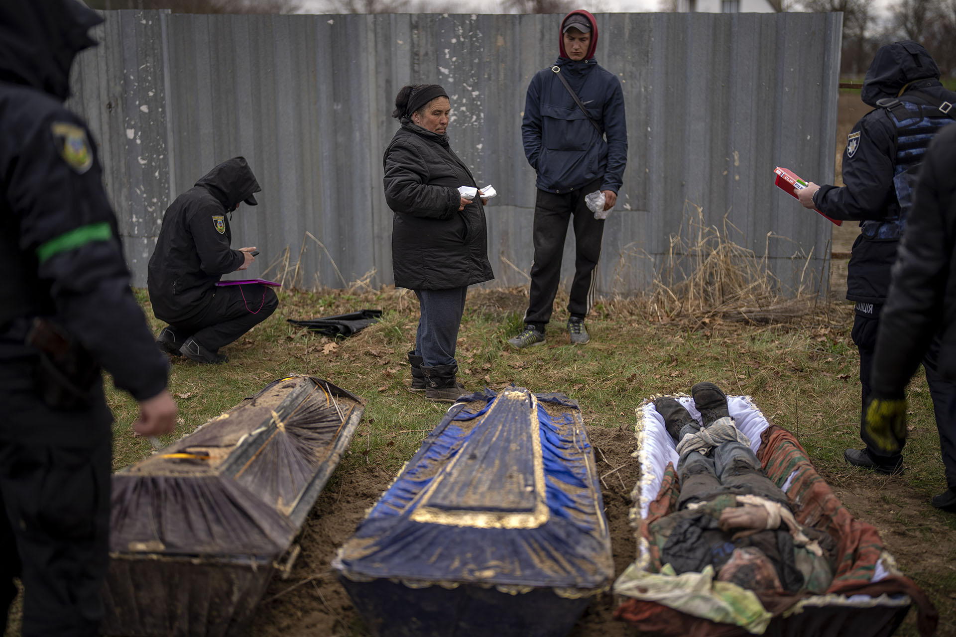Valya Naumenko, de 47 años, identifica el cuerpo de su esposo Pavlo Ivanyuk, de 57 años, asesinado por el ejército ruso, durante una exhumación de cuatro civiles asesinados y enterrados en una fosa común en Mykulychi. (AP Foto/Emilio Morenatti) 