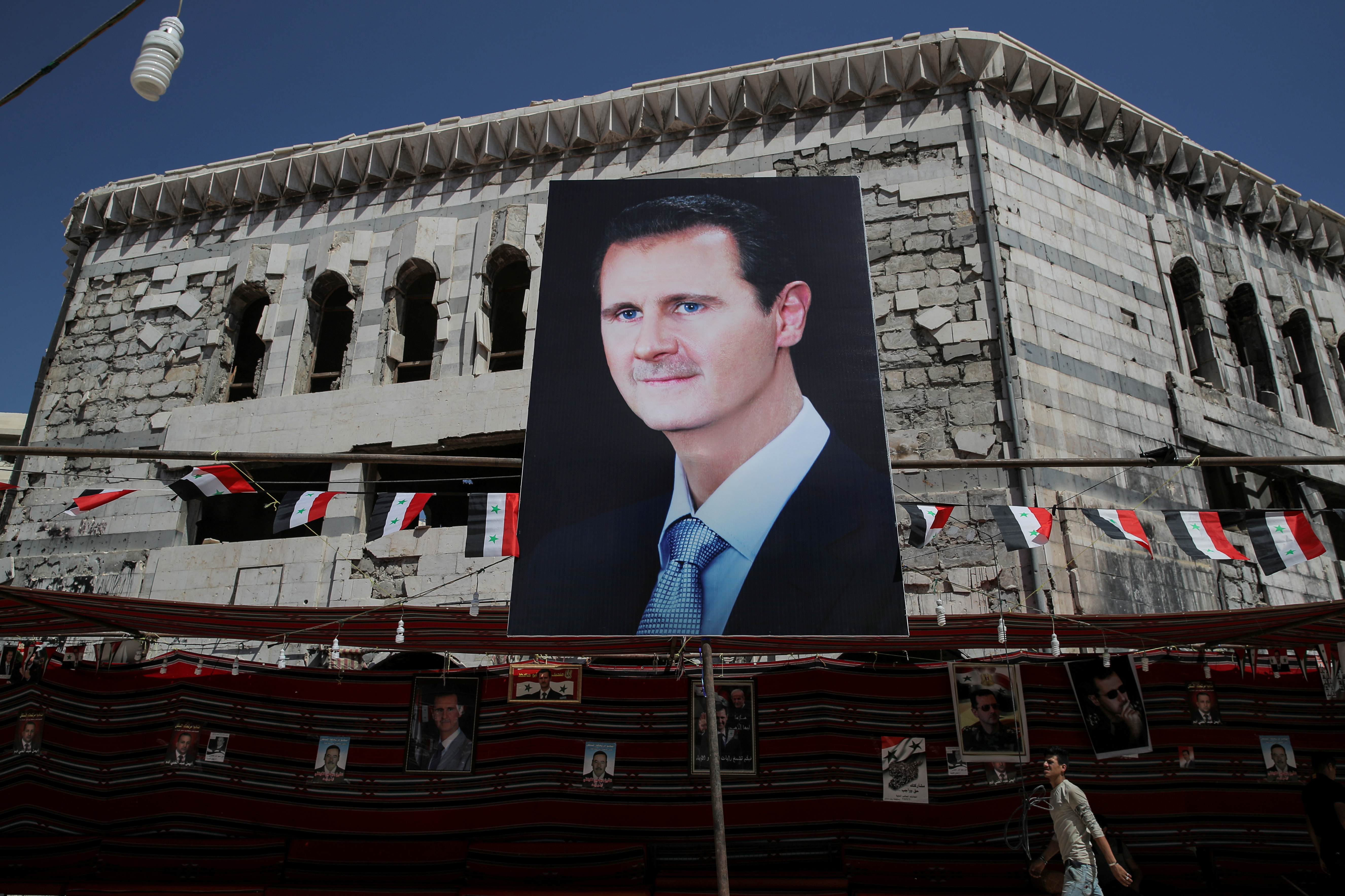 Un hombre pasa junto a una pancarta que representa al presidente sirio Bashar al-Assad en Douma, en las afueras de Damasco, Siria, el 17 de septiembre de 2018. REUTERS / Marko Djurica / Foto de archivo