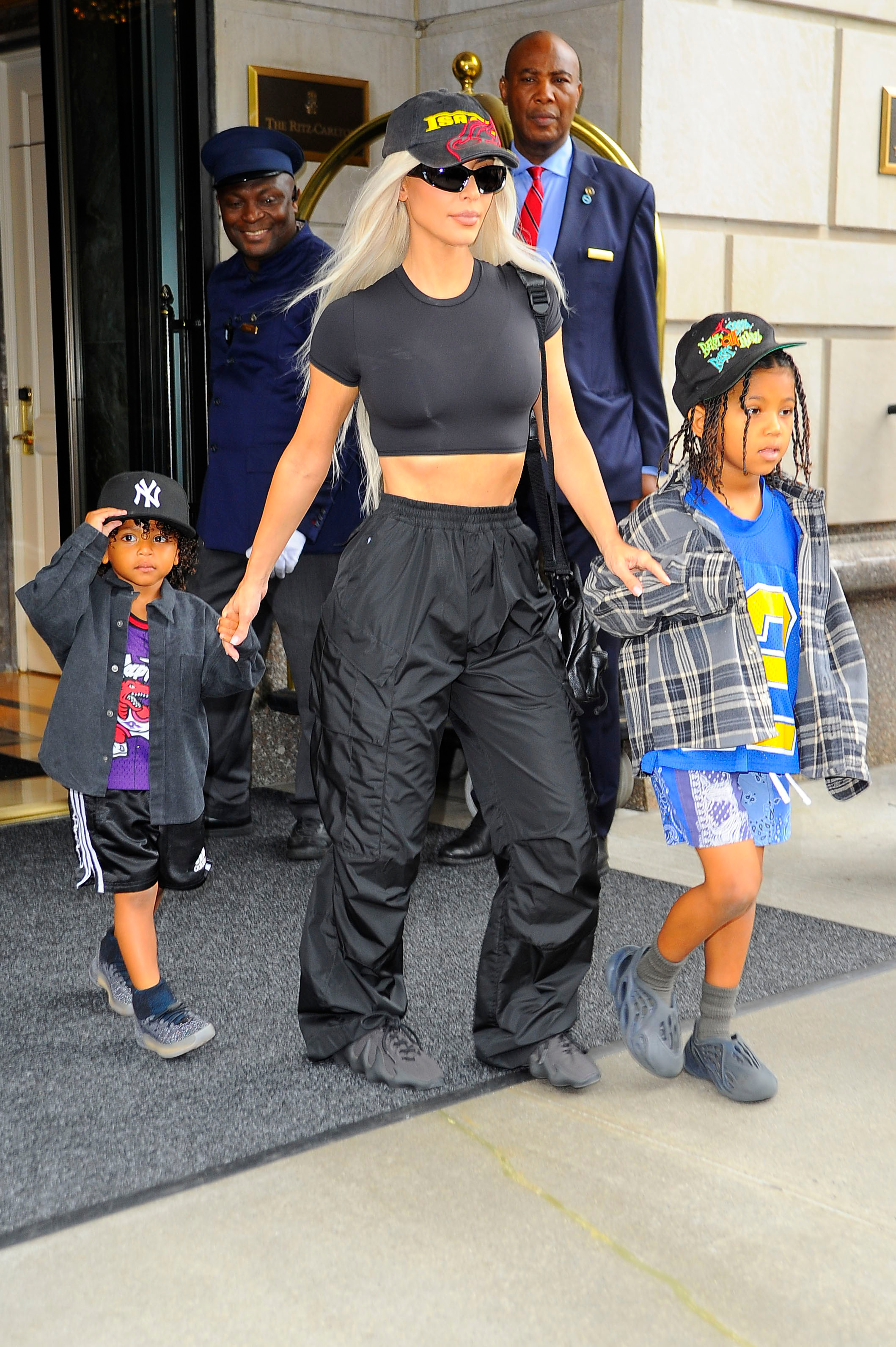 Paseo en familia. Kim Kardashian fue fotografiada cuando salía de su hotel en Nueva York acompañada por sus hijos Saint y Psalm. Lució un look total black de pantalón holgado, top, gorra, cartera y lentes de sol