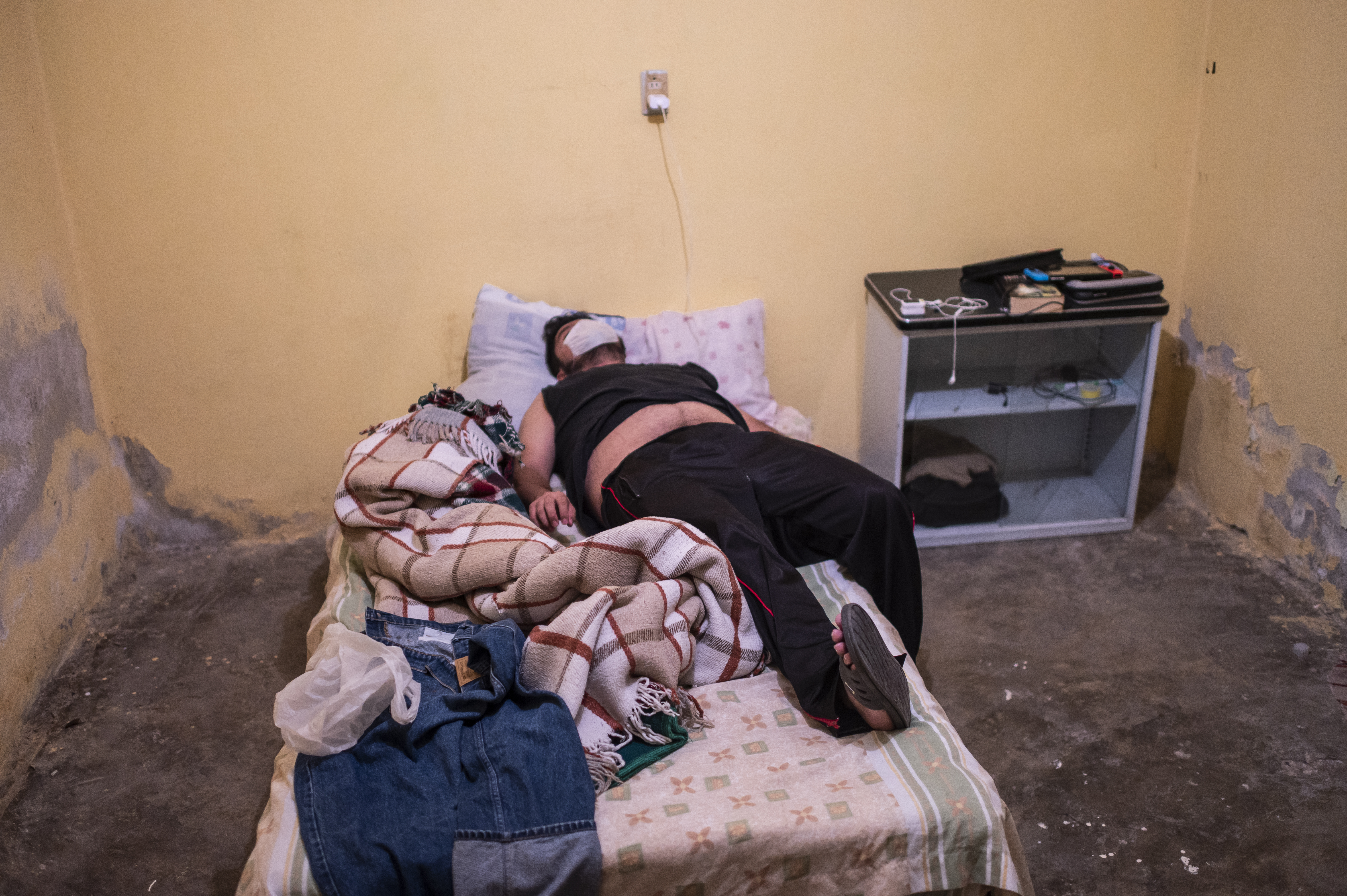 Un hombre con síntomas de COVID-19 yace en la cama después de que un paramédico lo revisó, en Ciudad Nezahualcóyotl, Estado de México, México, el 22 de junio de 2020 durante la nueva pandemia de coronavirus. (Foto por Pedro PARDO / AFP)