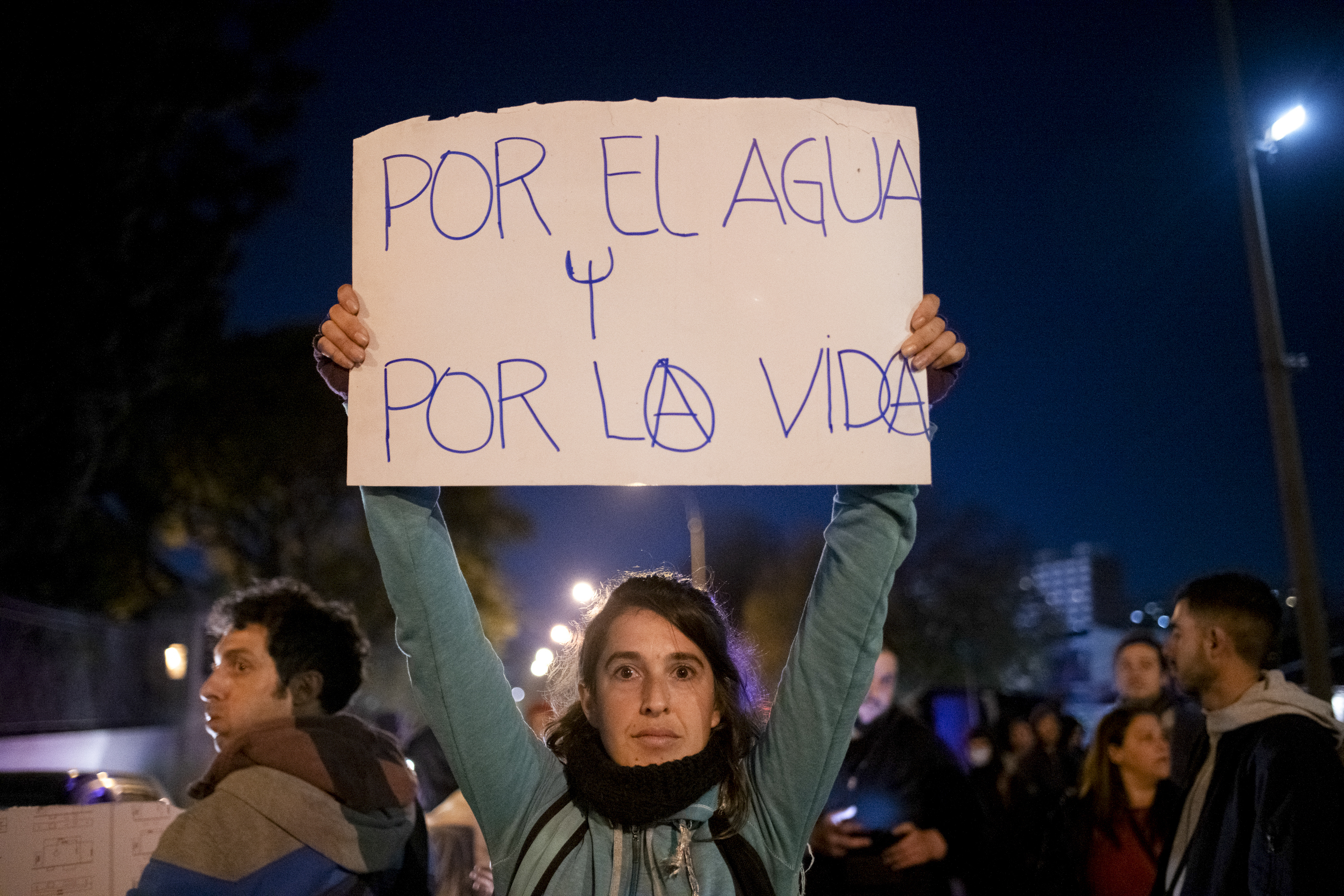 Una manifestante sostiene un cartel mientras protesta contra la falta de agua potable en Montevideo (AP Foto/Santiago Mazzarovich)