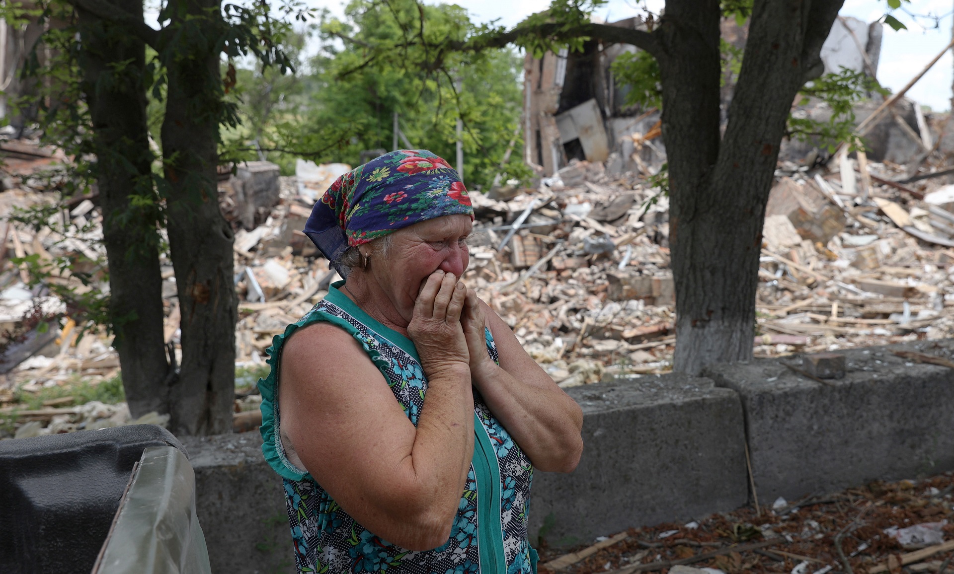 Raisa, residente en Lysychansk, llora frente a los escombros de una escuela destruida (AFP)