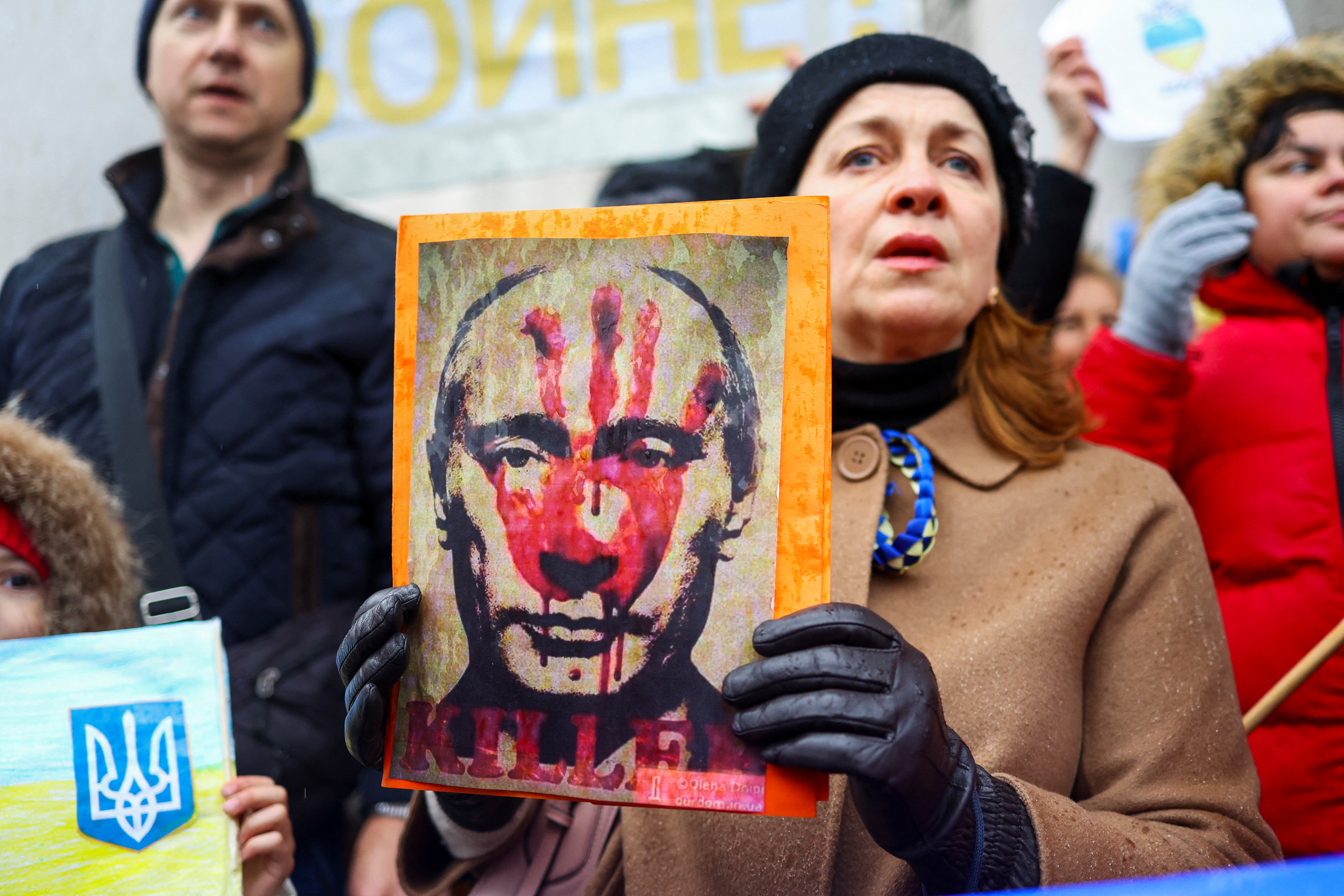 Una mujer sostiene una foto del presidente ruso Vladimir Putin en una manifestación contra la invasión a Ucrania, en Liubliana, Eslovenia, el 25 de febrero (Reuters)