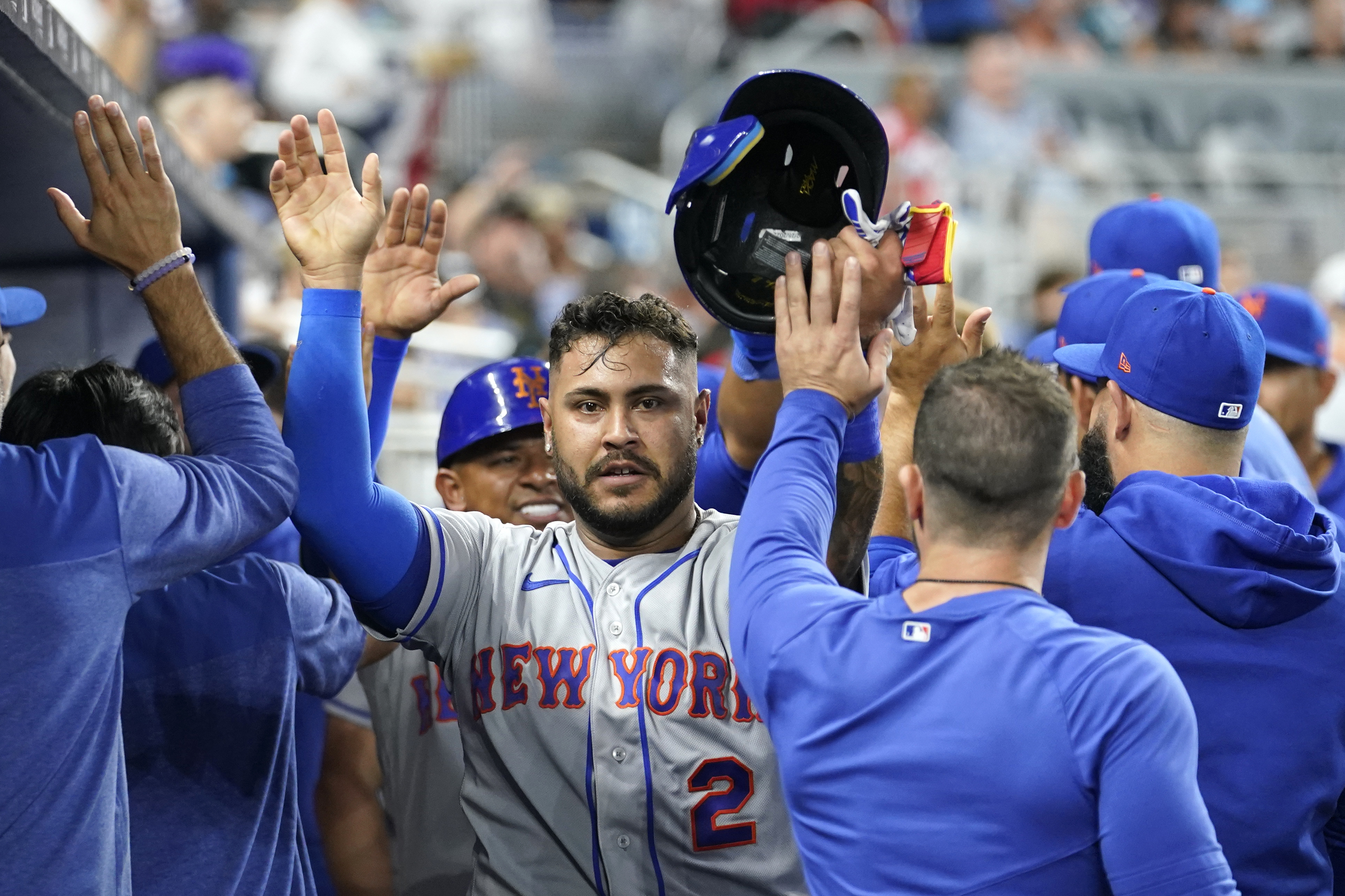 Omar Narvez of the New York Mets celebrates in the dugout after scoring on Brandon Nimmo's double against the Miami Marlins, Thursday, March 30, 2023. (AP Photo/Lynne Sladky)