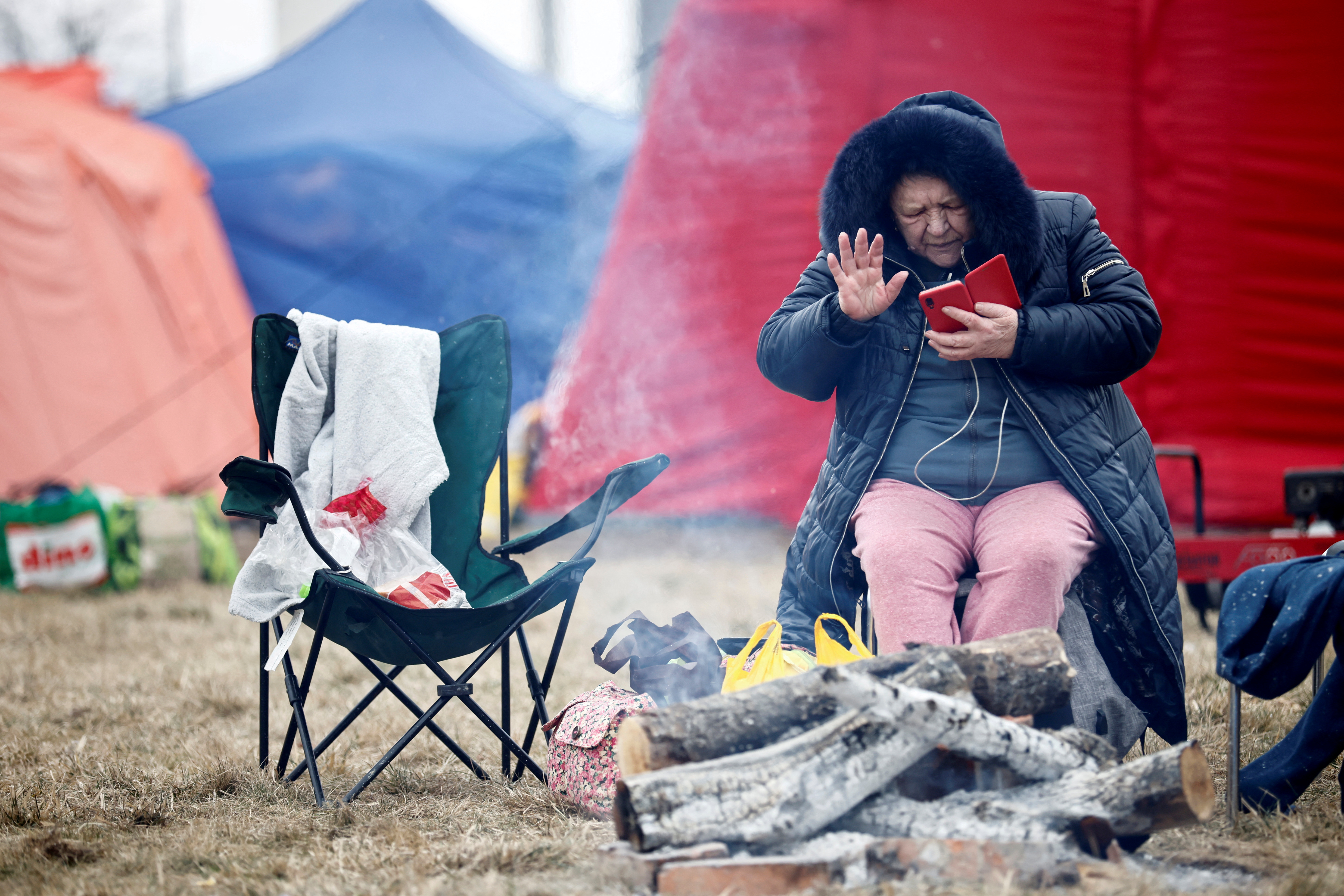 Una mujer que huye de la invasión rusa de Ucrania se sienta en un campamento temporal en Przemysl, Polonia. (REUTERS/Yara Nardi)
