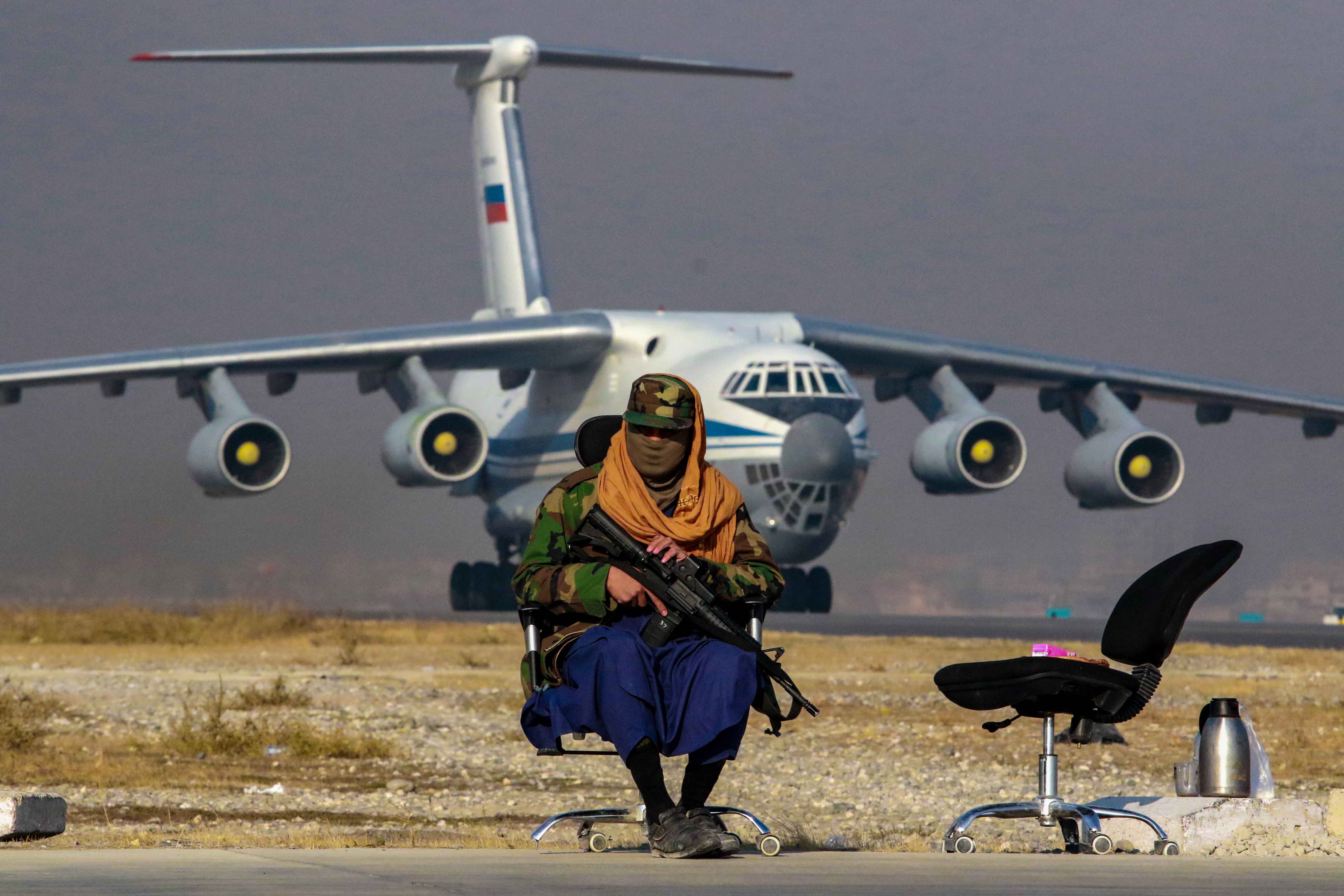 Un talibán armado vigila a un lado de la pista de aterrizaje tras la llegada de un avión con material de ayuda proveniente de Rusia, en Kabul, Afganistán, en una imagen de archivo. EFE/ Stringer
