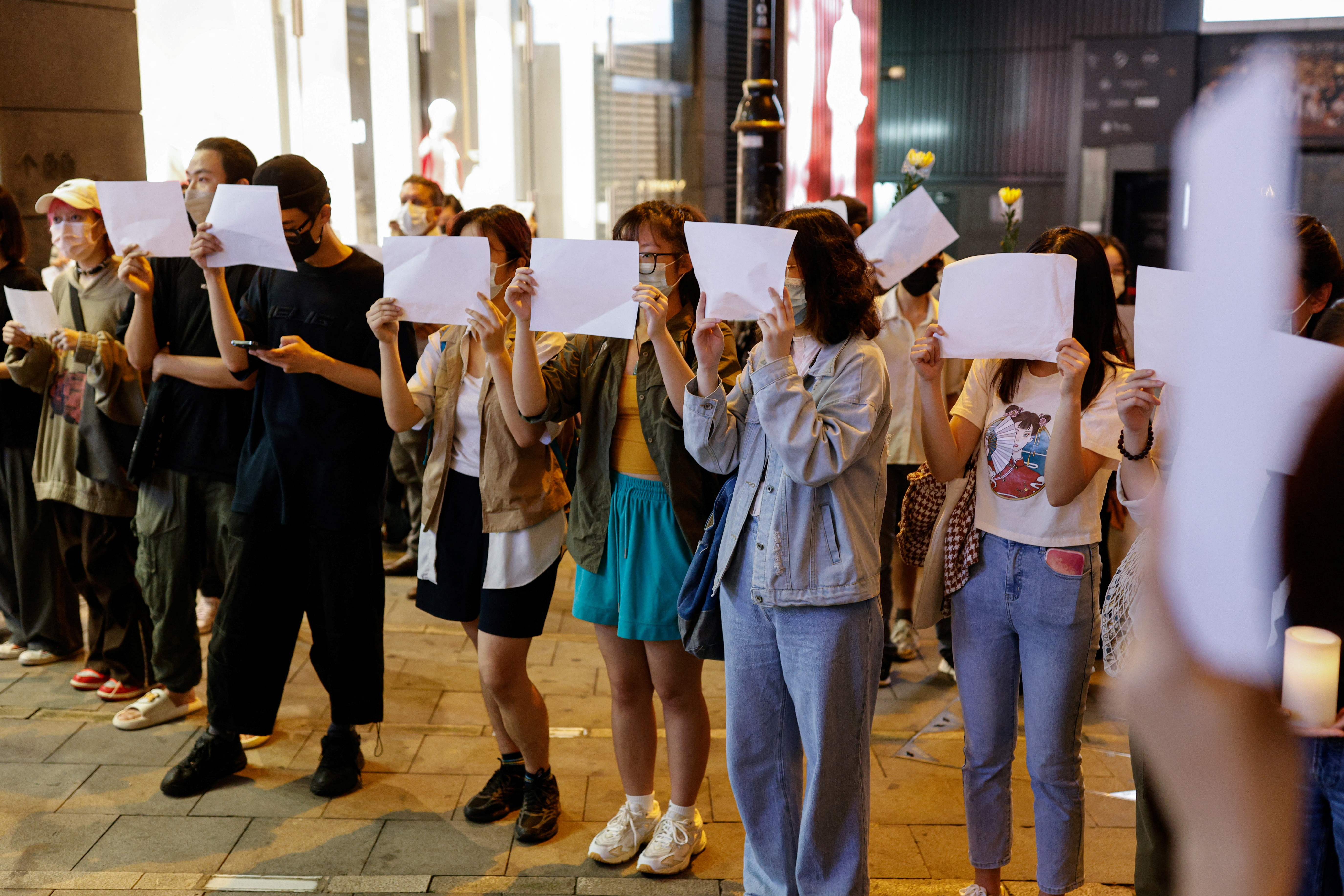People hold sheets of paper in protest over coronavirus disease (COVID-19) restrictions in mainland China, in Hong Kong