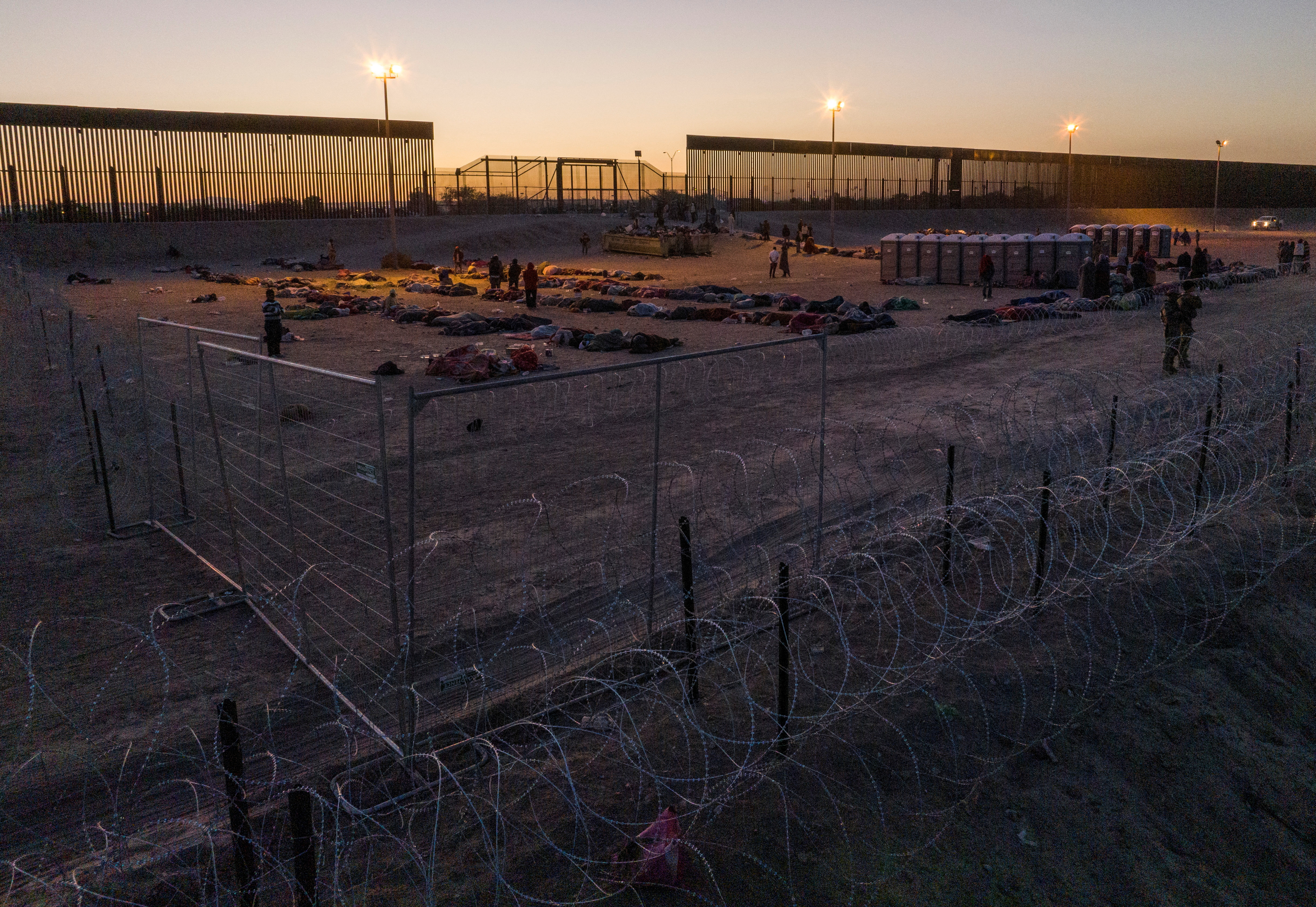 Migrantes reunidos en la frontera entre Estados Unidos y México al amanecer después del levantamiento del Título 42 cerca de El Paso, Texas (REUTERS/Julio Cesar Chavez)