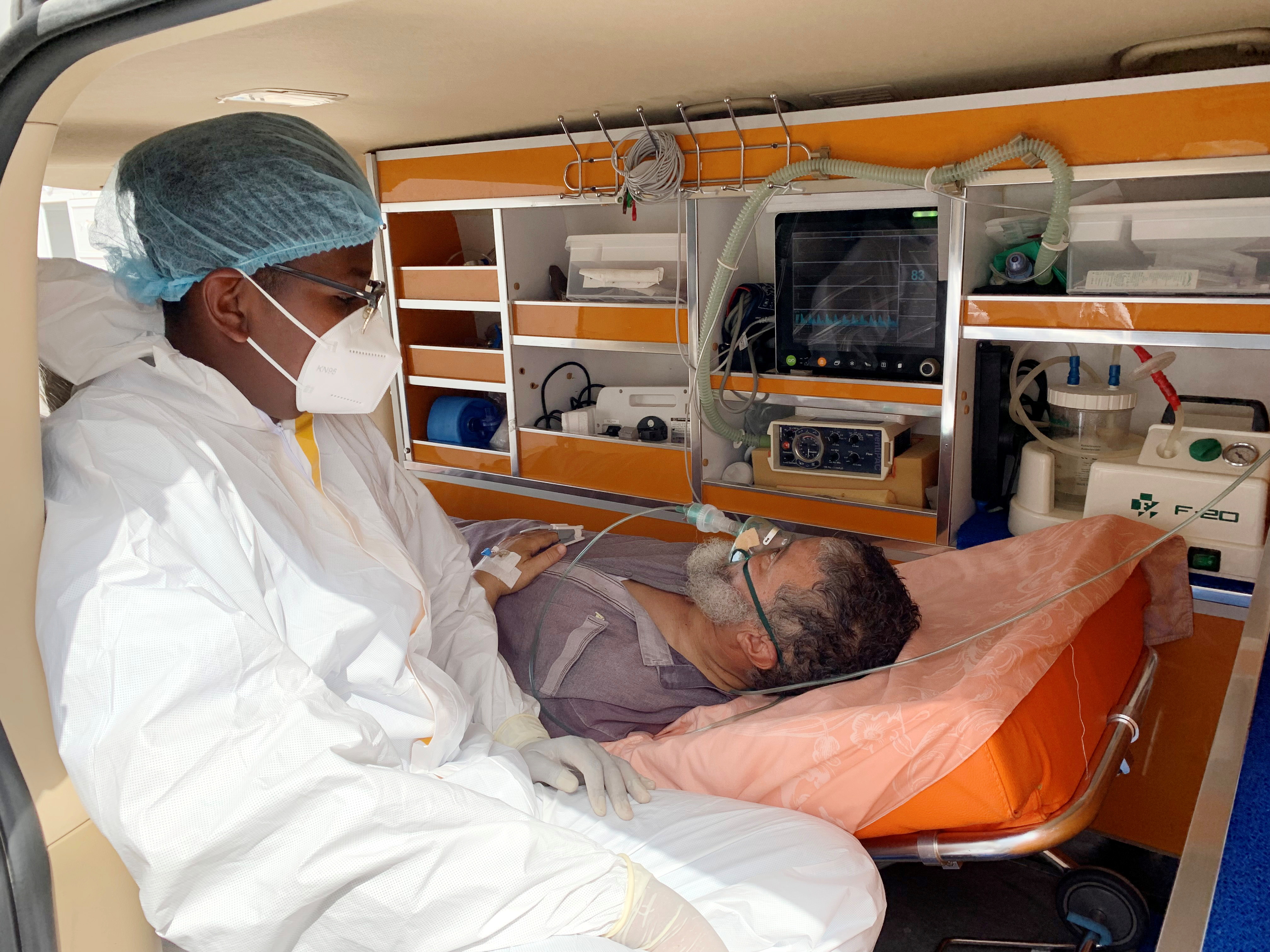 Una enfermera se sienta junto a un paciente en una ambulancia fuera de un centro de cuarentena para la enfermedad por coronavirus (COVID-19) mientras espera ser admitido en Misrata, Libia, el 13 de julio de 2021. Fotografía tomada el 13 de julio de 2021. REUTERS / Ayman al-Sahili