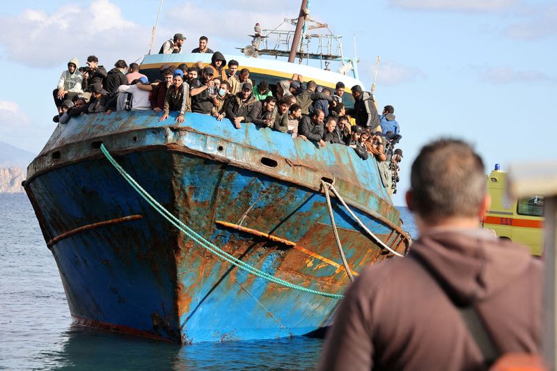 FILE PHOTO: Migrants board a fishing boat in the port of Paleochora, following a rescue operation off the island of Crete, Greece, November 22, 2022. REUTERS/Stringer