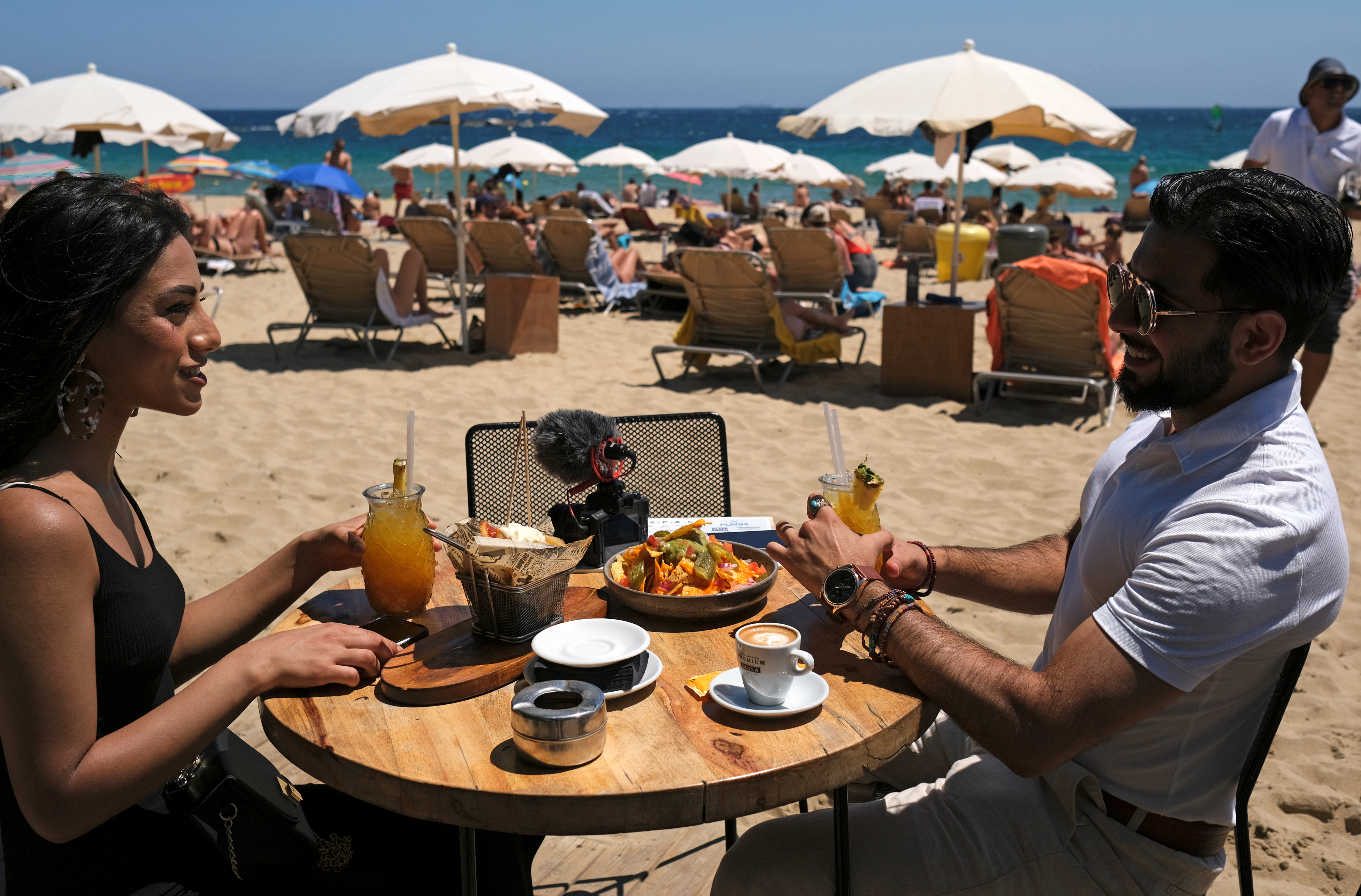 Una pareja disfruta de una comida en la playa de la Barceloneta
