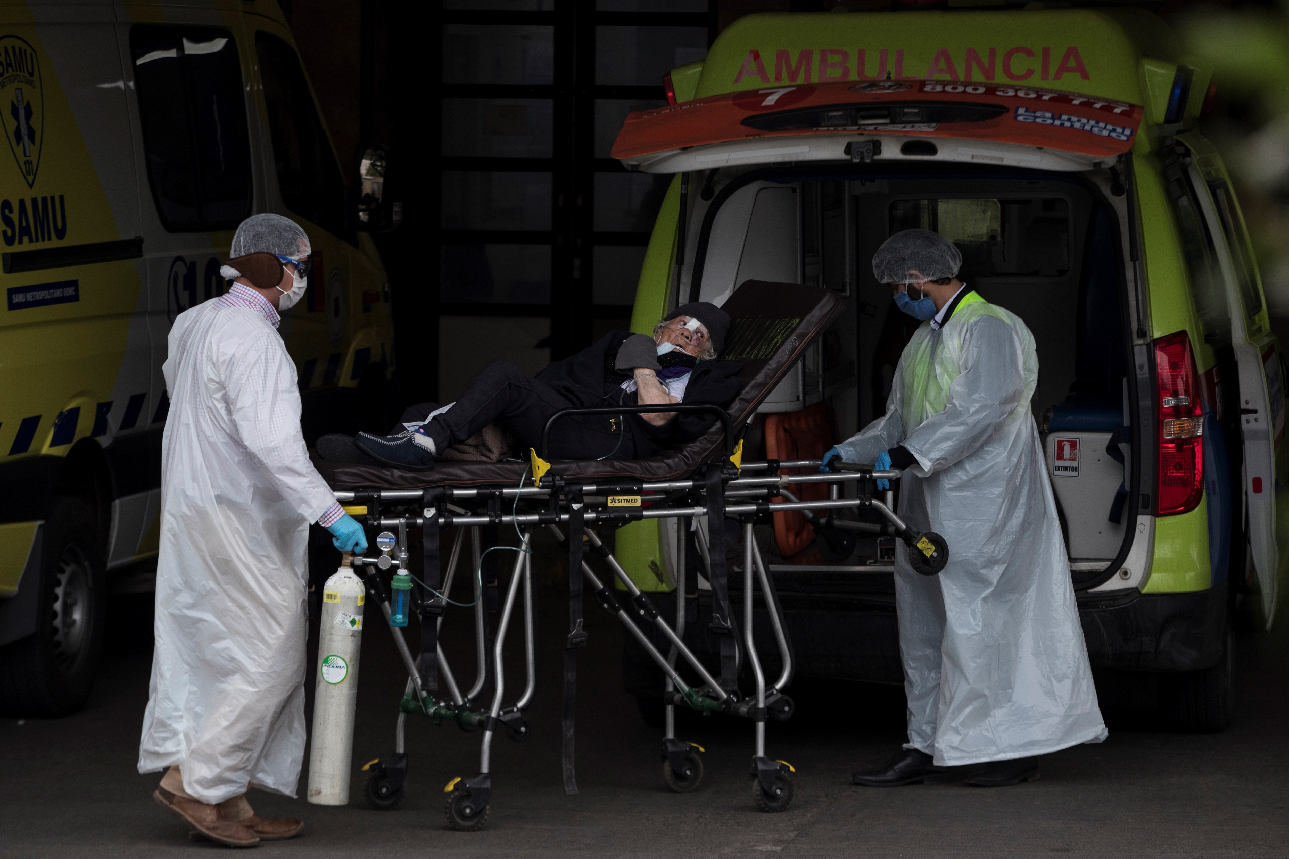Trabajadores del Servicio de Atención Médico de Urgencias (SAMU) y del Hospital San José; trasladan a un paciente en Santiago de Chile (EFE/Alberto Valdés)
