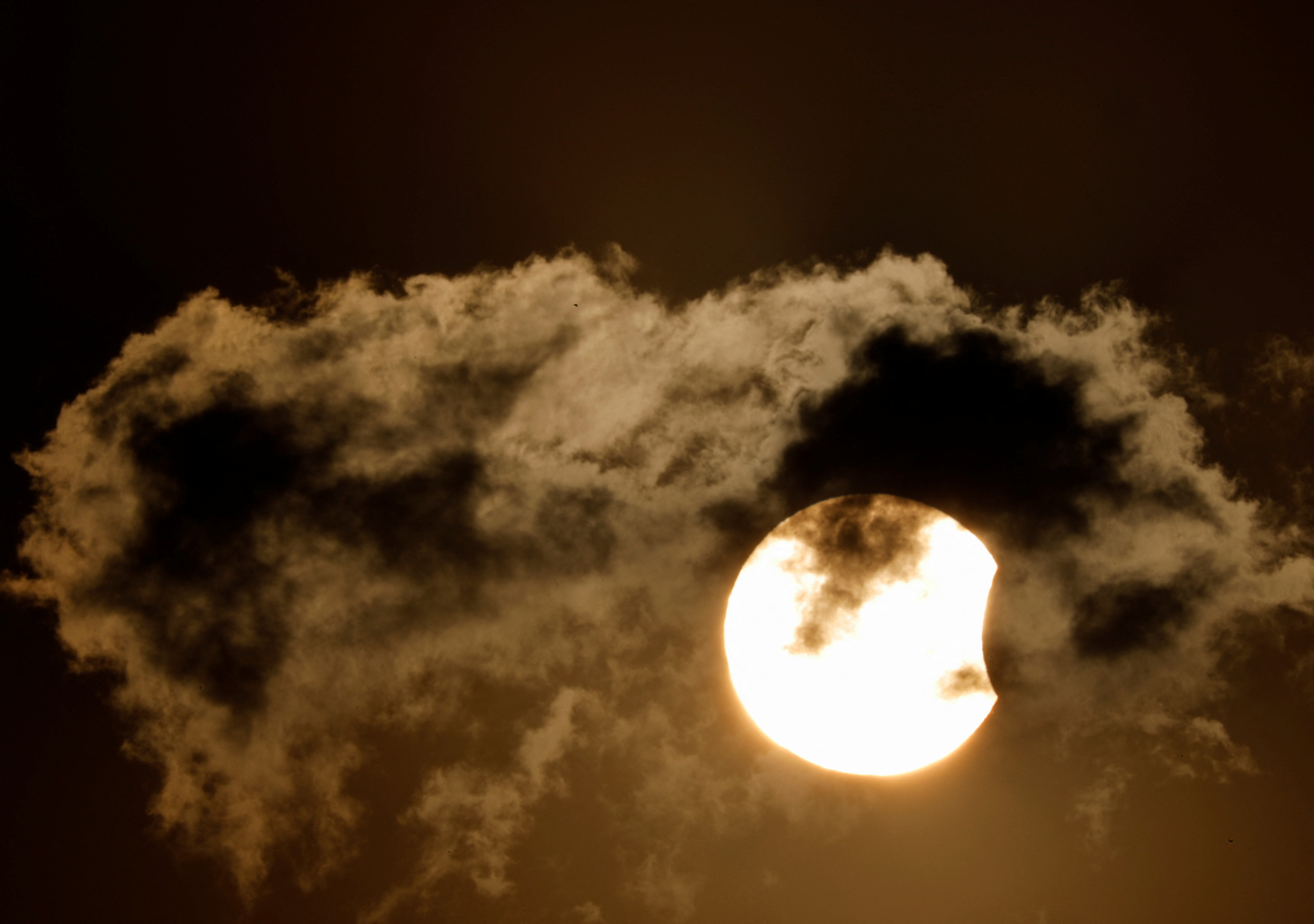 El eclipse solar parcial capturado detrás de una nube durante la puesta del sol en Kathmandu, Nepal (REUTERS/Navesh Chitrakar)