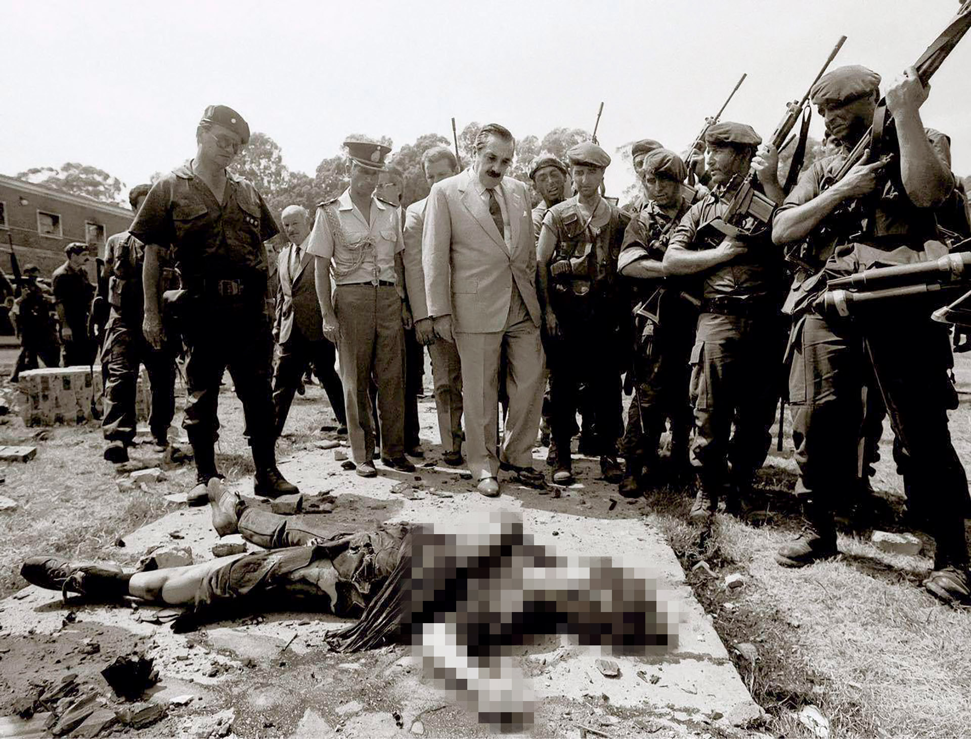 El presidente Raúl Alfonsín frente al cuerpo de uno de los guerrilleros del MTP luego del intento de copamiento del Regimiento de La Tablada (Víctor Buggé)
