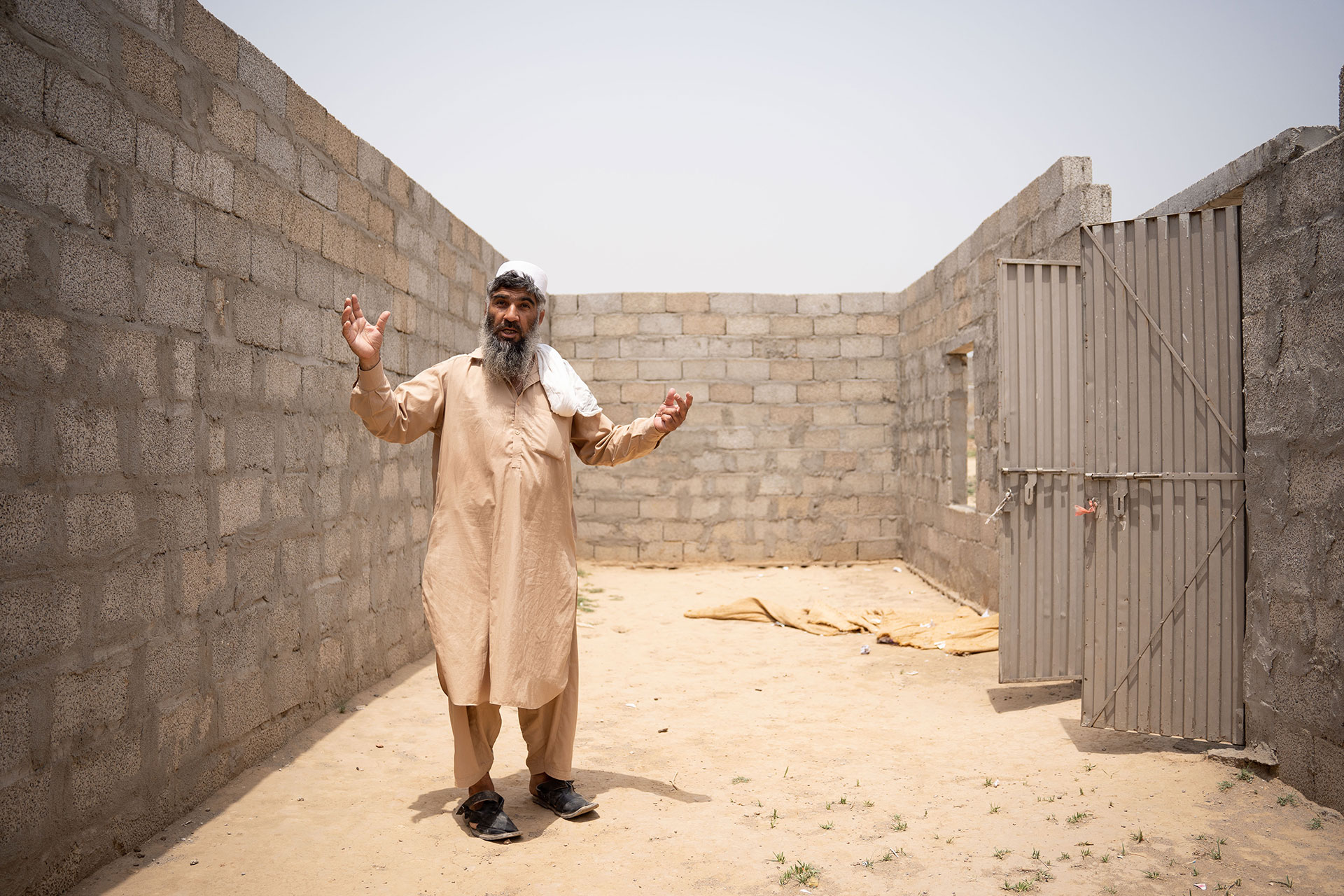 Un anciano de una aldea muestra los cimientos de una escuela sin terminar en un campo de refugiados en las afueras de Islamabad. 