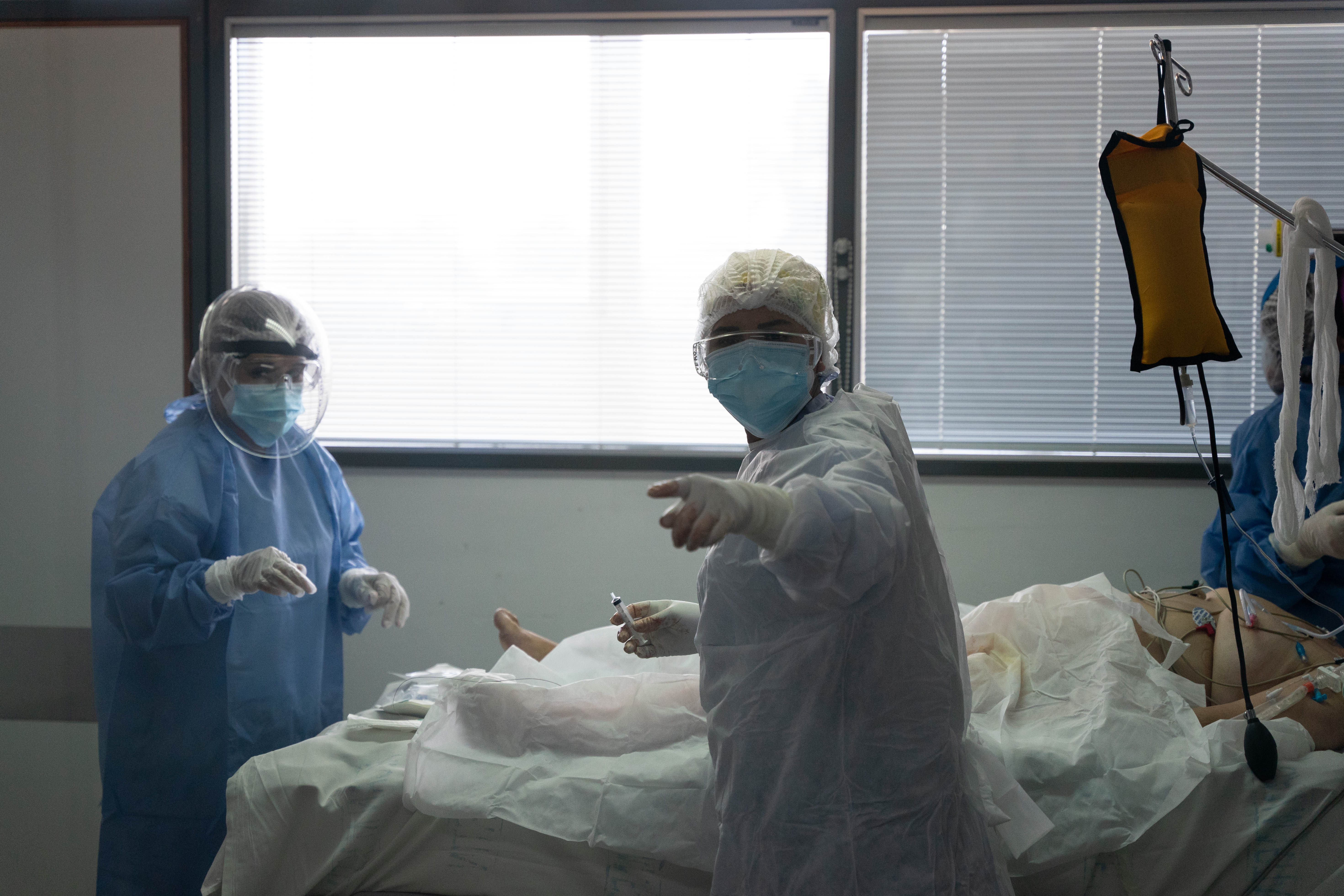 Las médicas de la UTI COVID trabajan sobre una paciente que mnutos más tarde necesitará ser pronada (dada vuelta). (Foto: Franco Fafasuli)