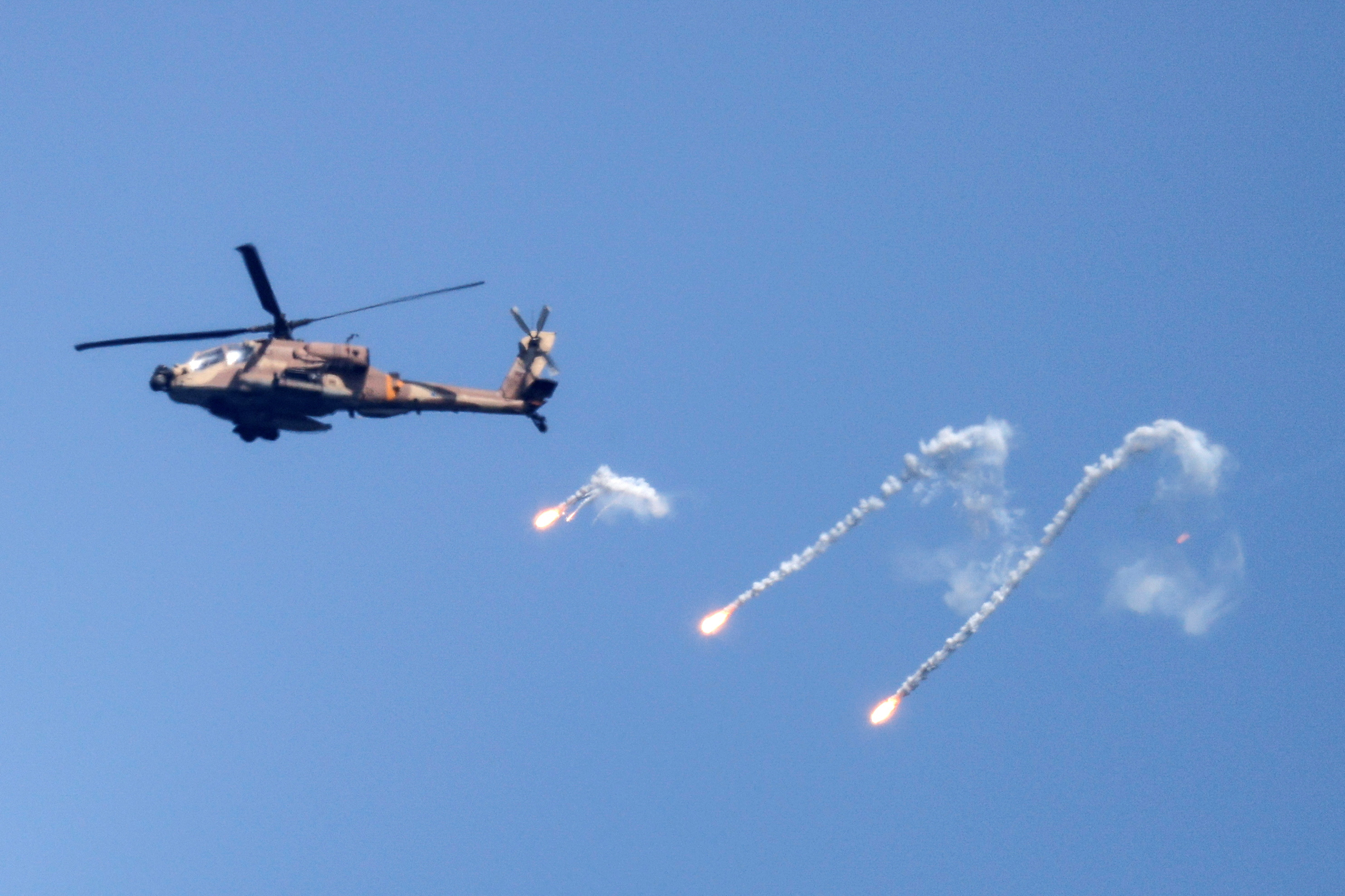 Un helicóptero Apache de la Fuerza Aérea israelí dispara bengalas en el cielo sobre la frontera entre Israel y Gaza el 7 de agosto de 2022. REUTERS/Amir Cohen