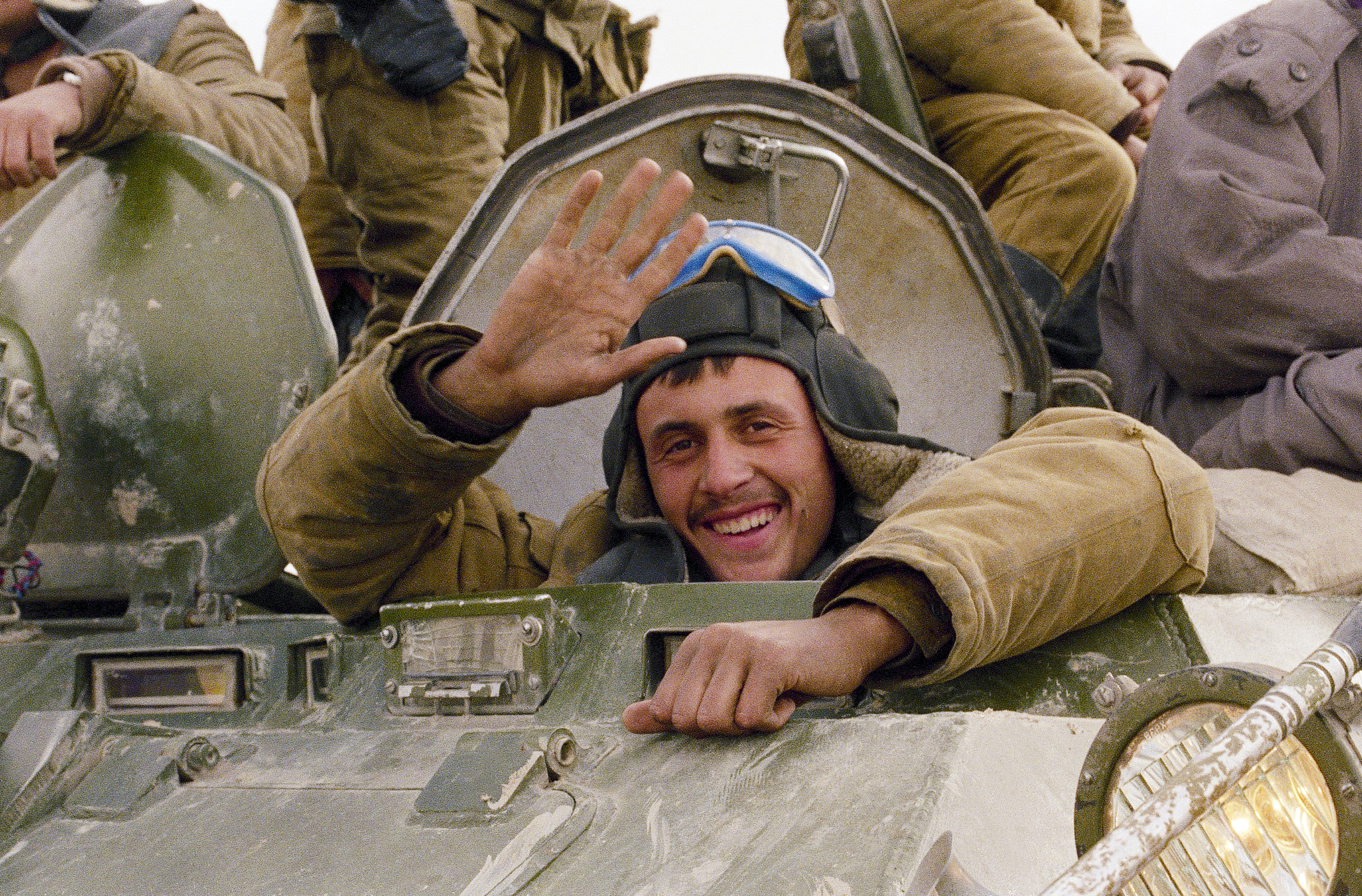 ARCHIVO - Una sonrisa y un saludo de un soldado soviético, mientras su convoy blindado regresa a la Unión Soviética por una carretera del norte de Afganistán, el 7 de febrero de 1989. 