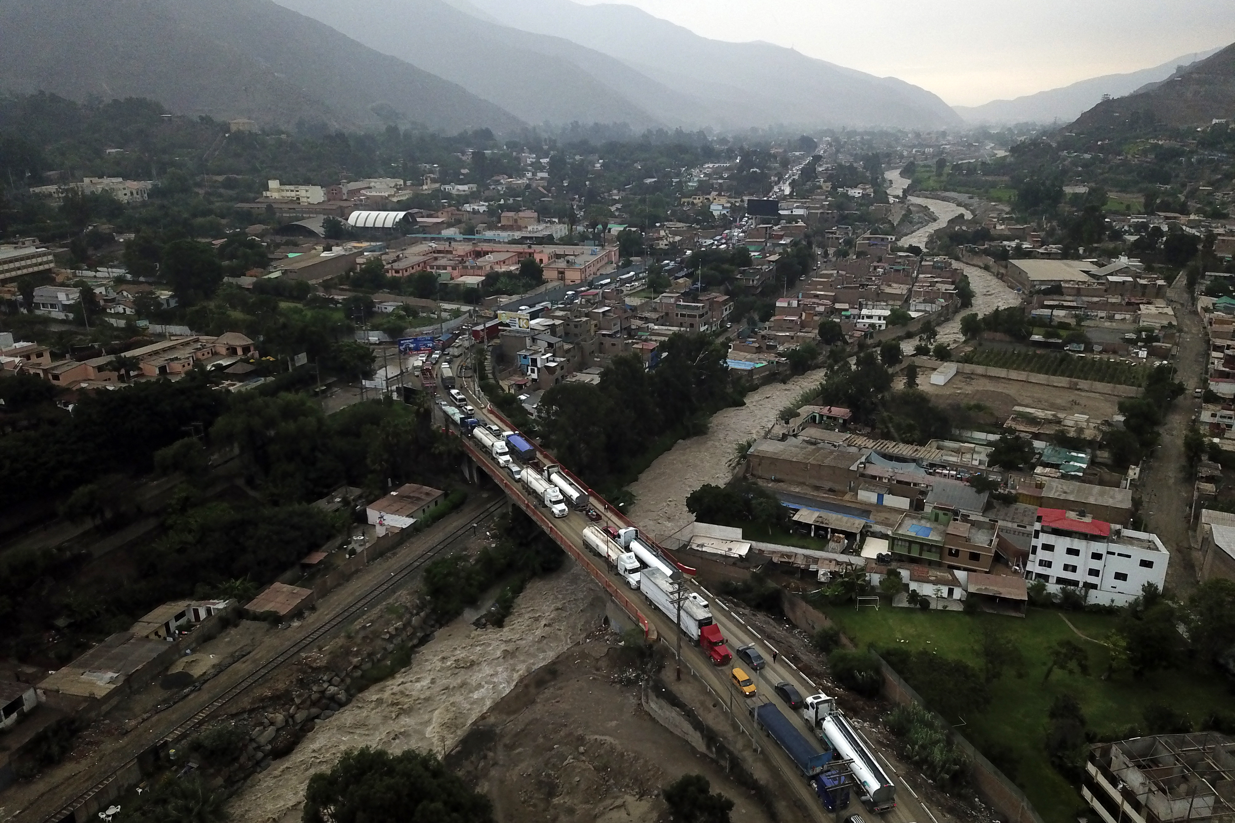 Esta fotografía aérea muestra camiones y automóviles bloqueando la principal vía de acceso de Lima al interior del país en los Andes luego de fuertes lluvias en Chaclacayo, al este de Lima, Perú. (AFP)