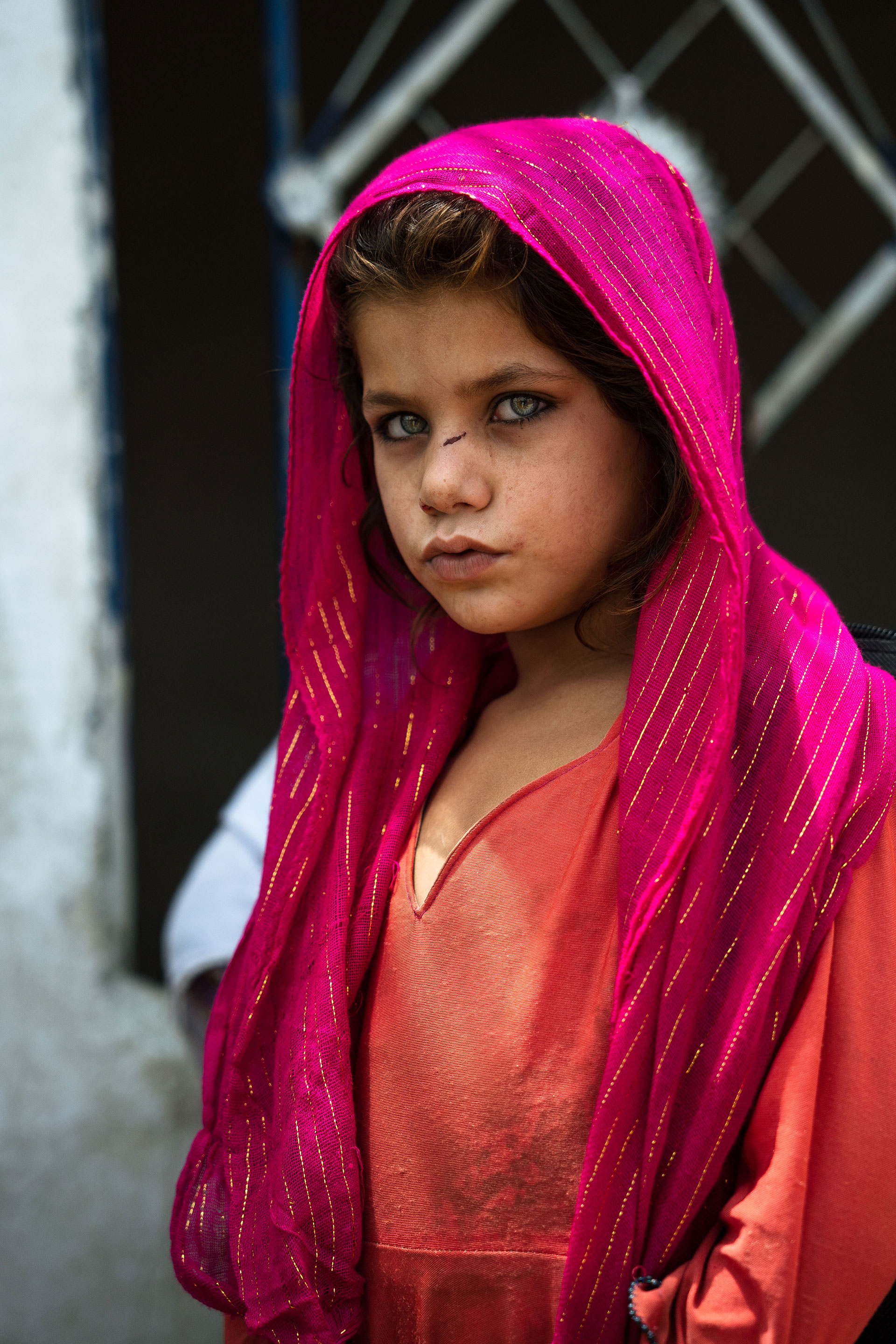 Una niña se para fuera de una escuela improvisada después de clase en un campo de refugiados en las afueras de Islamabad. 
