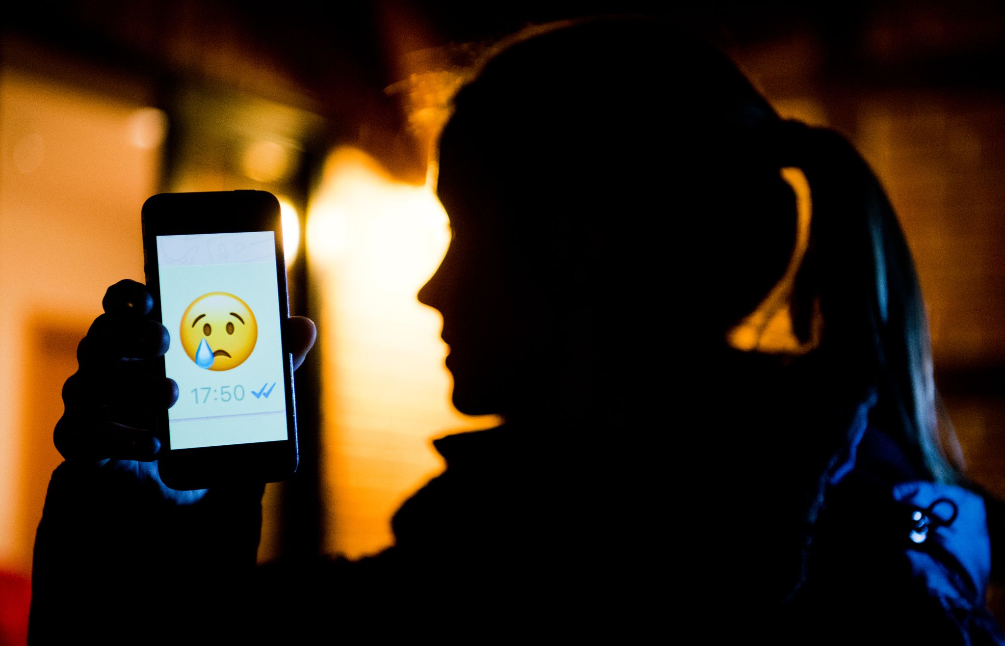 ARCHIVO - Una joven muestra en la pantalla de su móvil un emoji llorando. Foto: Julian Stratenschulte/dpa