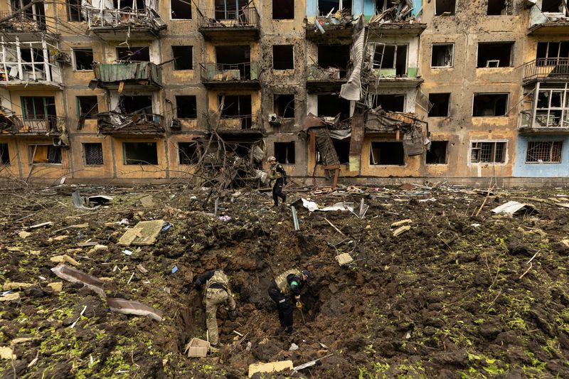 Militares ucranianos inspeccionan el sitio de un ataque con misiles frente a un edificio residencial dañado, en medio de la invasión de Rusia, en Dobropillia, en la región de Donetsk, Ucrania, el 30 de abril de 2022. REUTERS/Jorge Silva