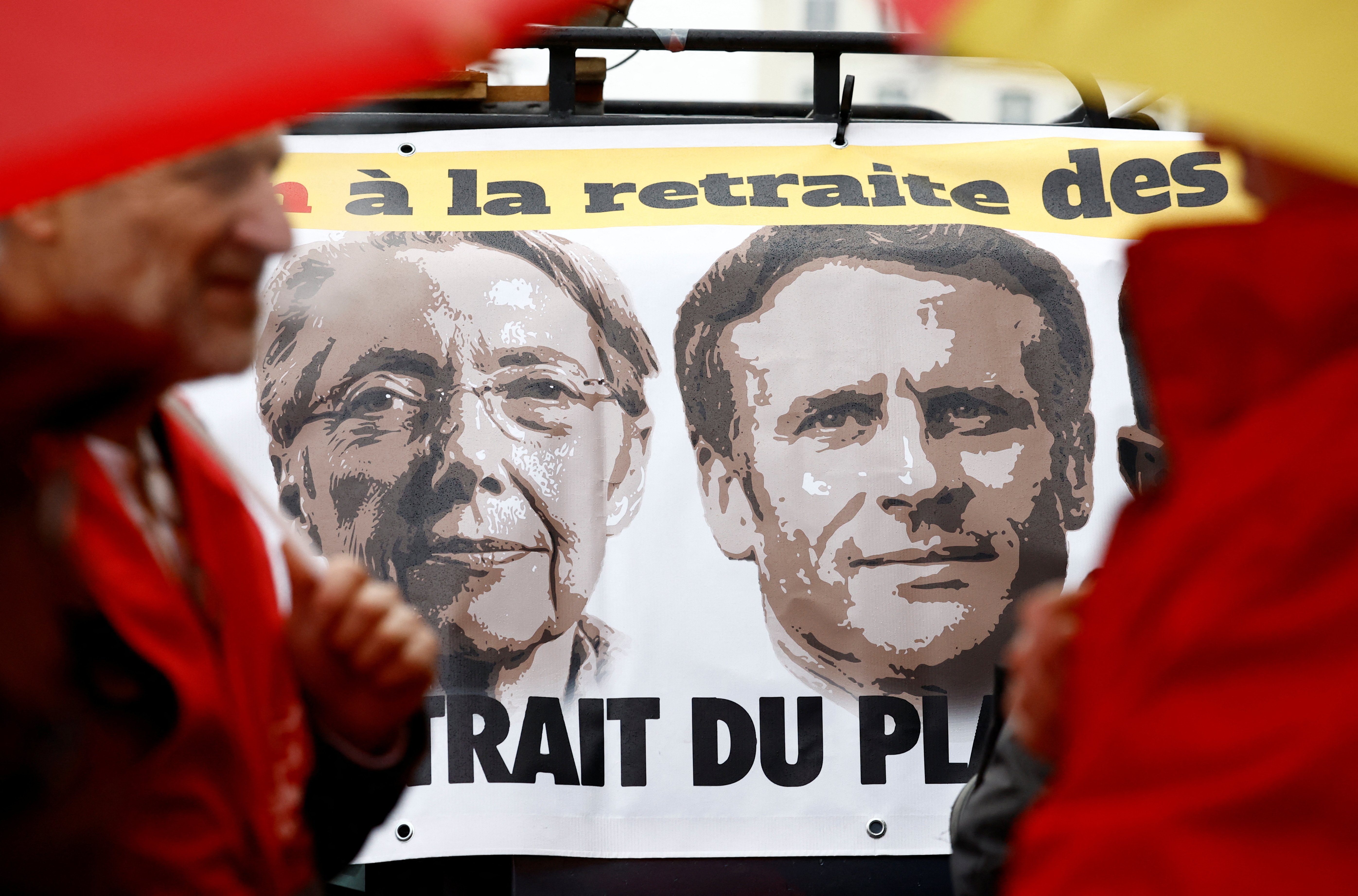 Una pancarta muestra el disgusto por la reforma del Presidente Emmanuel Macron y la Primera Ministra Elizabeth Borne. El Jefe de Estado se muestra inflexible, aunque su Jefa de Gobierno abre una puerta de diálogo.  