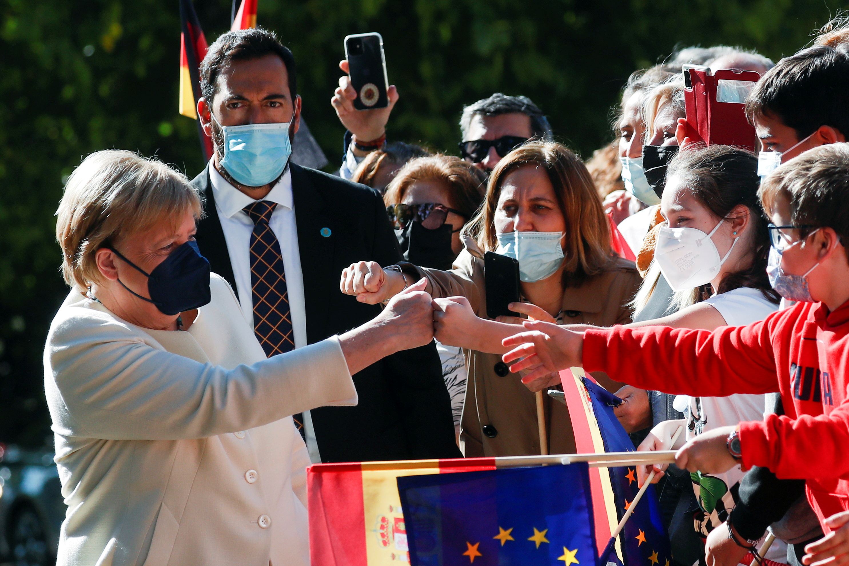 La canciller alemana Angela Merkel saluda a los escolares al llegar para recibir el "Premio Europeo Carlos V" en el Monasterio de Yuste, en la región occidental española de Cáceres, el 14 de octubre de 2021. REUTERS / Susana Vera 