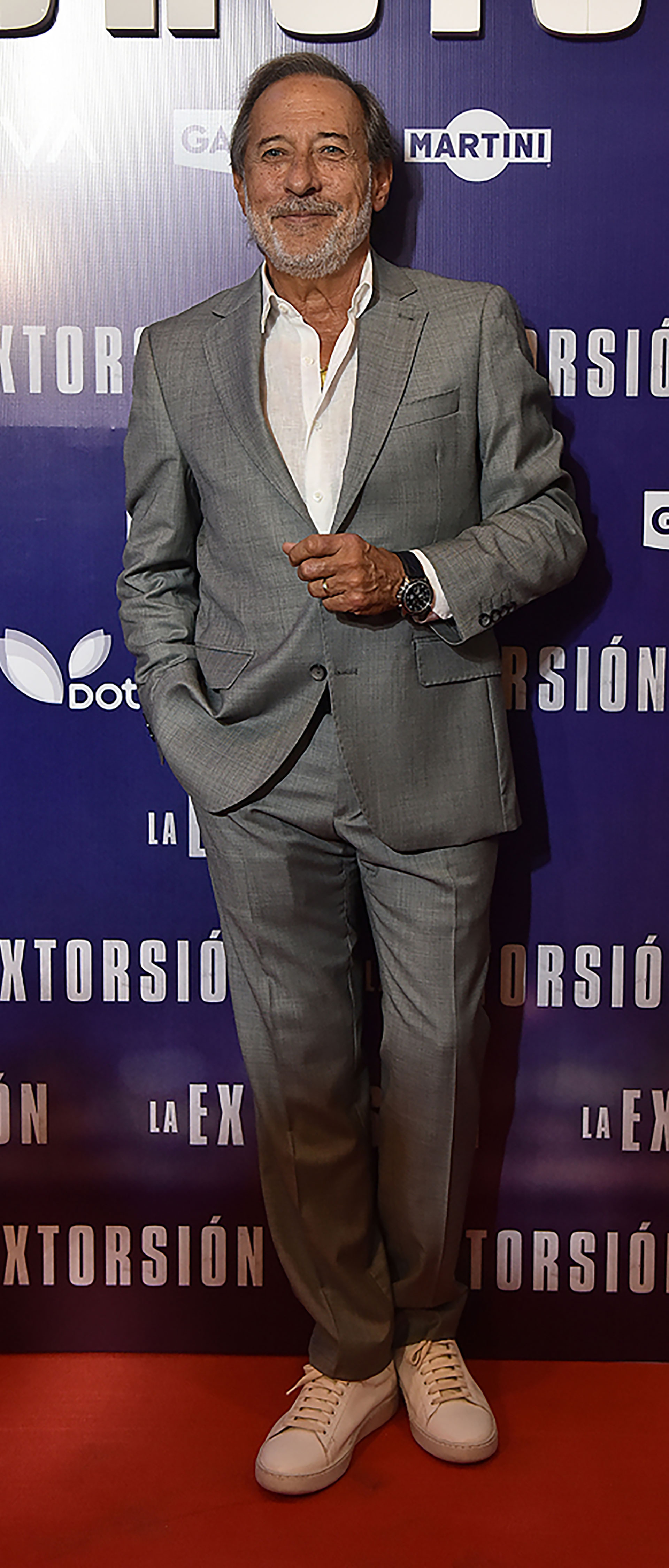 Guillermo Francella in the previous event of the movie La Extorción.  He chose a gray suit without a tie and white sneakers